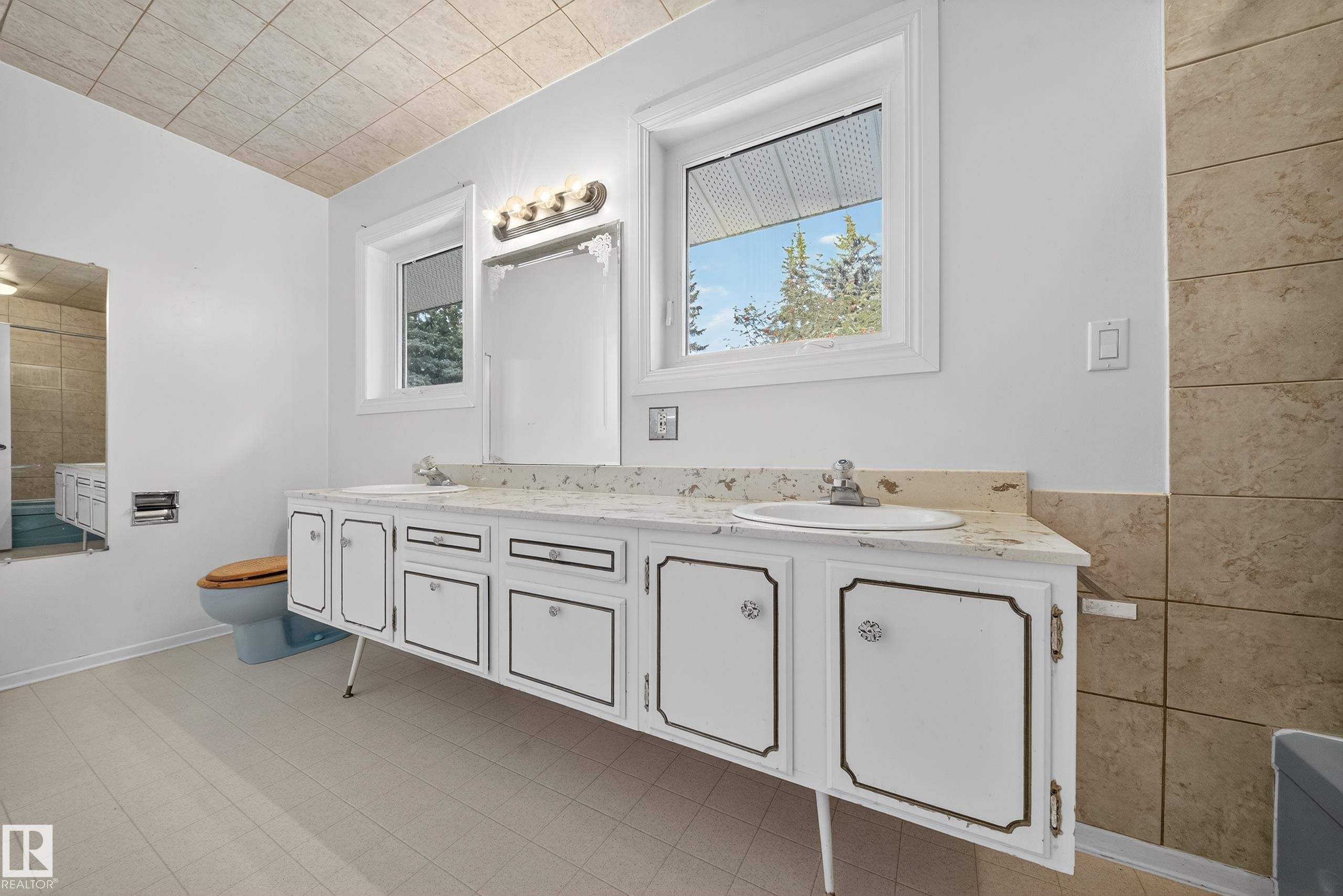 Dual sink vanity with white cabinetry and patterned countertop - 707 65 Avenue, Edmonton, AB