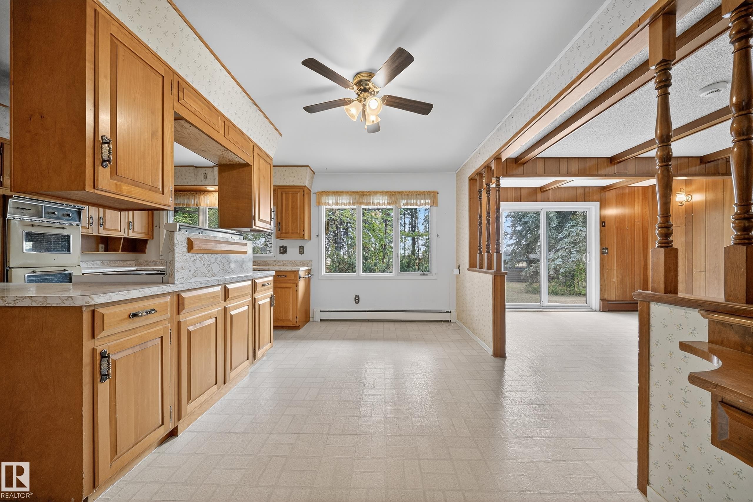Kitchen featuring wood cabinetry, laminate countertops, and a built-in oven - 707 65 Avenue, Edmonton, AB