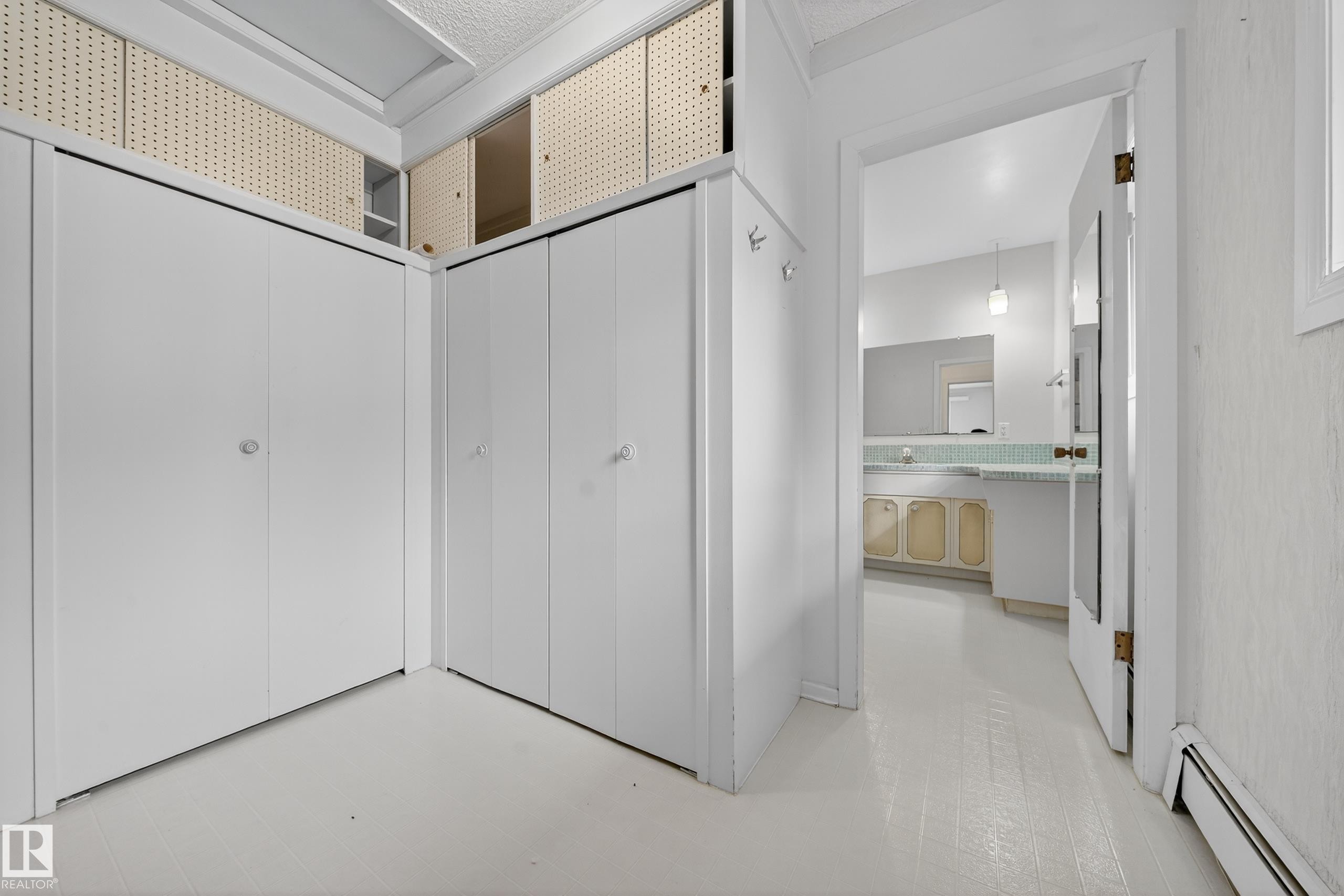 White interior featuring built-in white closet doors and overhead storage - 707 65 Avenue, Edmonton, AB