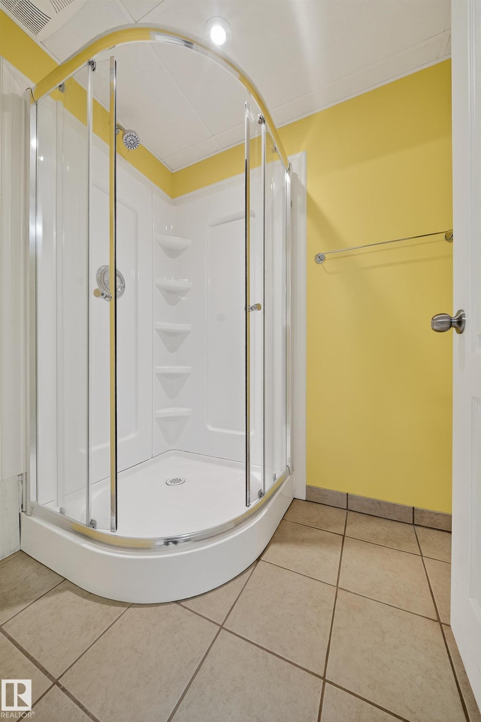 Curved glass shower enclosure with white shower base and integrated shelving - 707 65 Avenue, Edmonton, AB