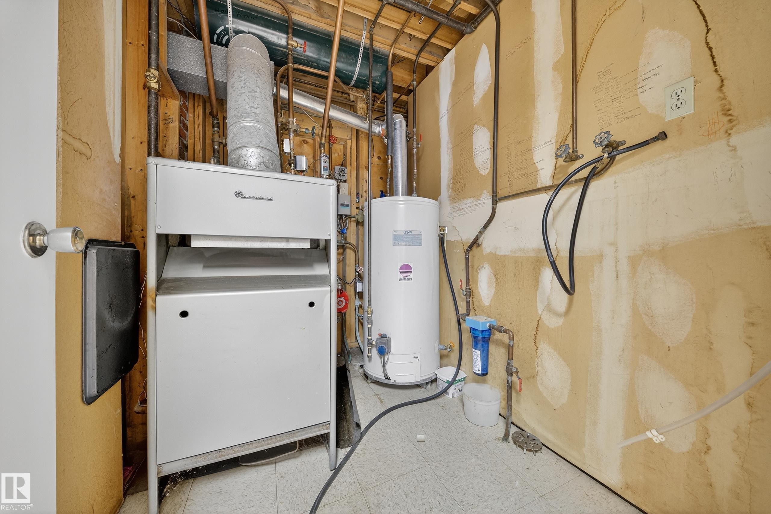 Utility area featuring a water heater, furnace, copper piping, and a water filtration system - 707 65 Avenue, Edmonton, AB