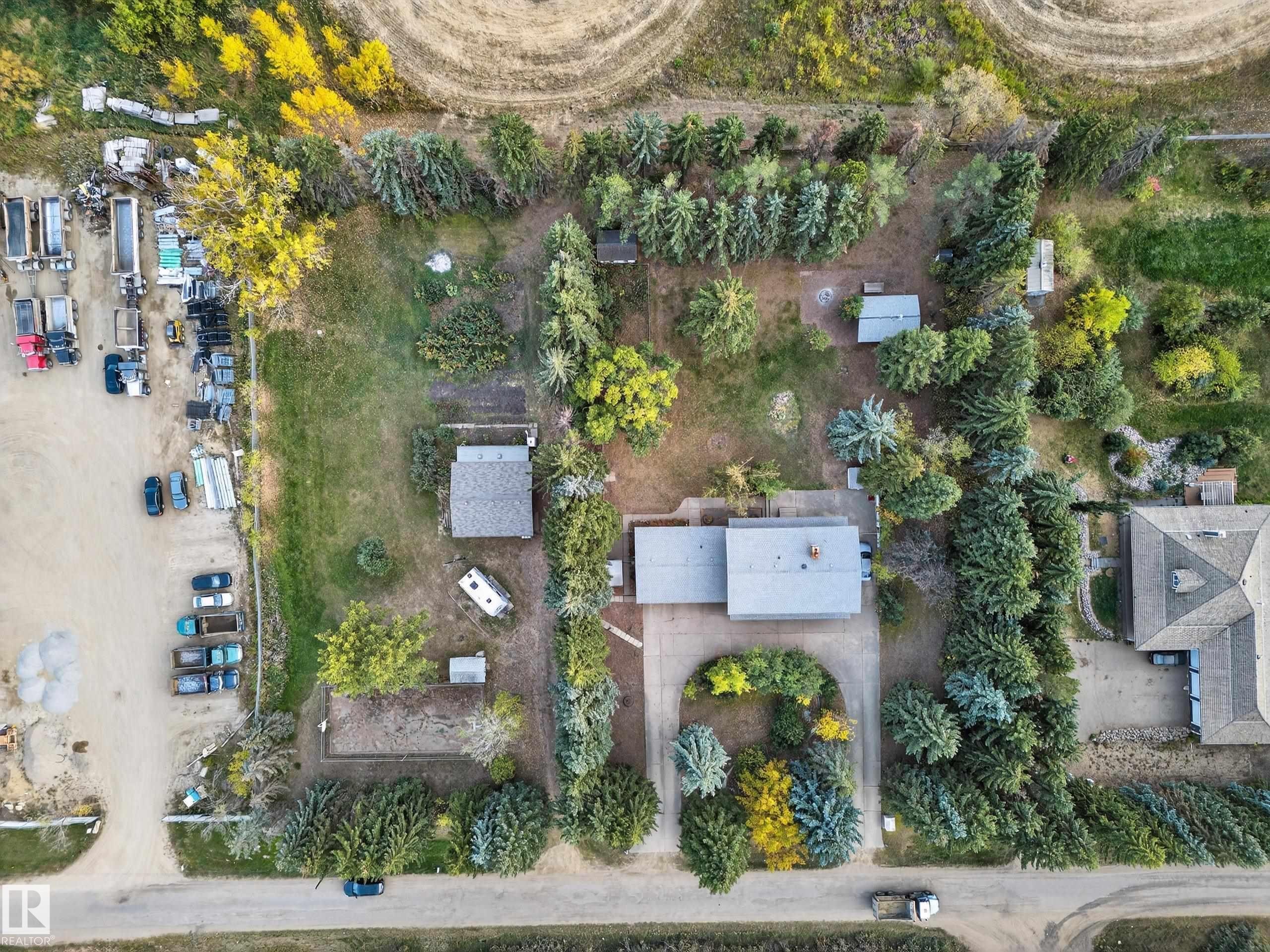Expansive lot featuring mature perimeter trees, multiple outbuildings, and a main residence with an attached garage - 707 65 Avenue, Edmonton, AB