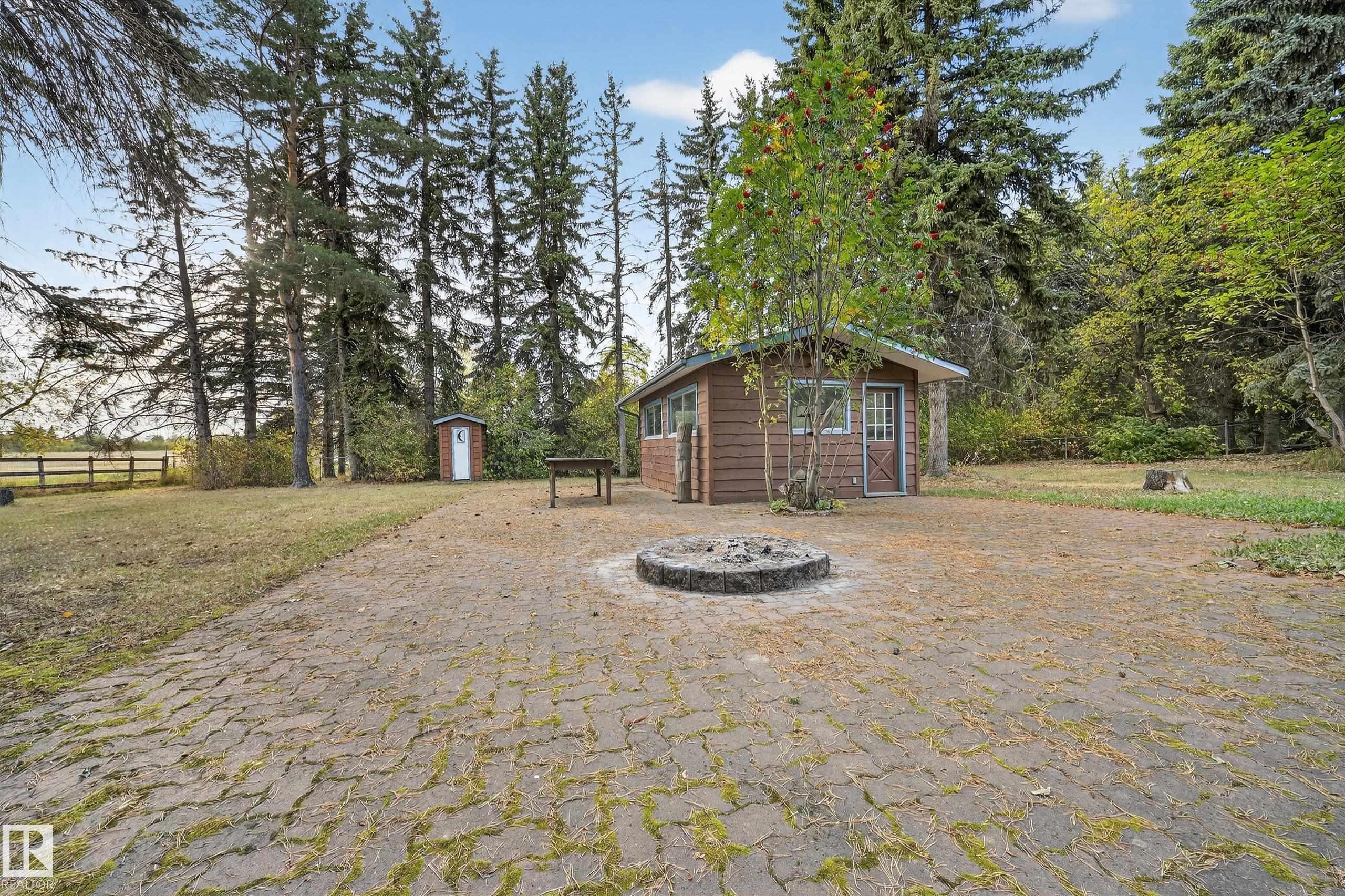 Outbuilding featuring wood-look siding, a green shingle roof, and multiple windows - 707 65 Avenue, Edmonton, AB