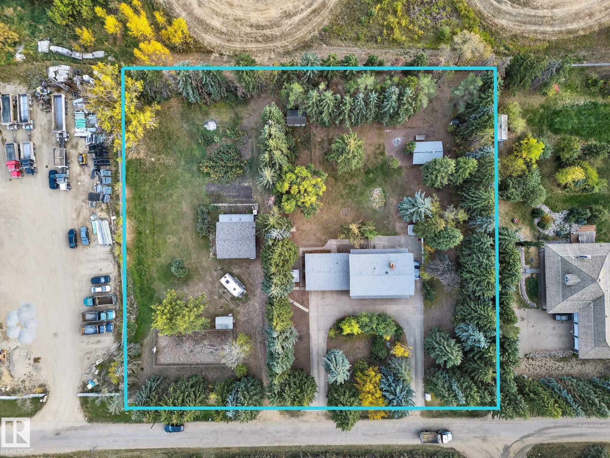 Aerial view of a residential property with extensive tree coverage and multiple outbuildings - 707 65 Avenue, Edmonton, AB