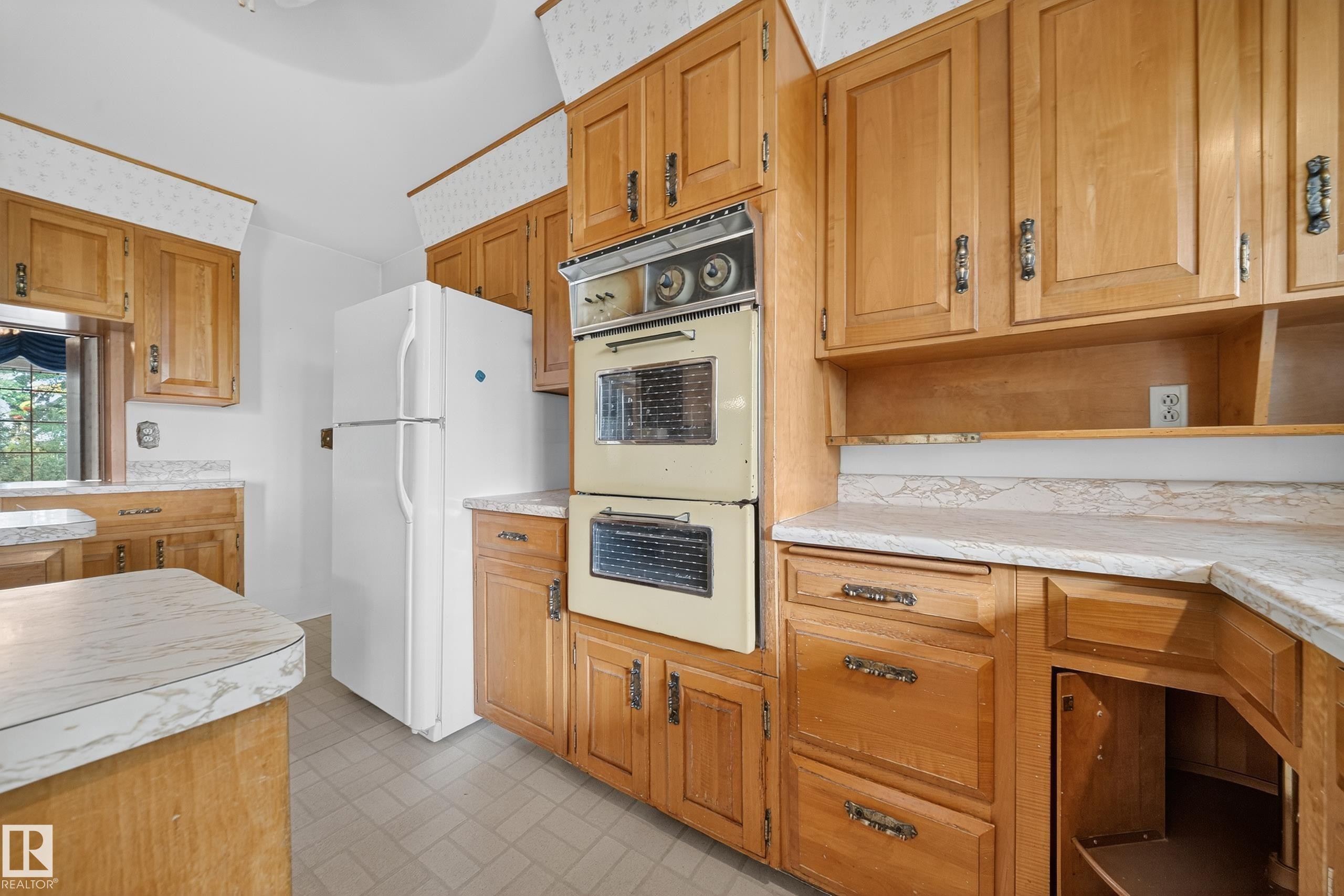 Kitchen featuring wood cabinetry, laminate countertops, a double wall oven, and tile flooring - 707 65 Avenue, Edmonton, AB