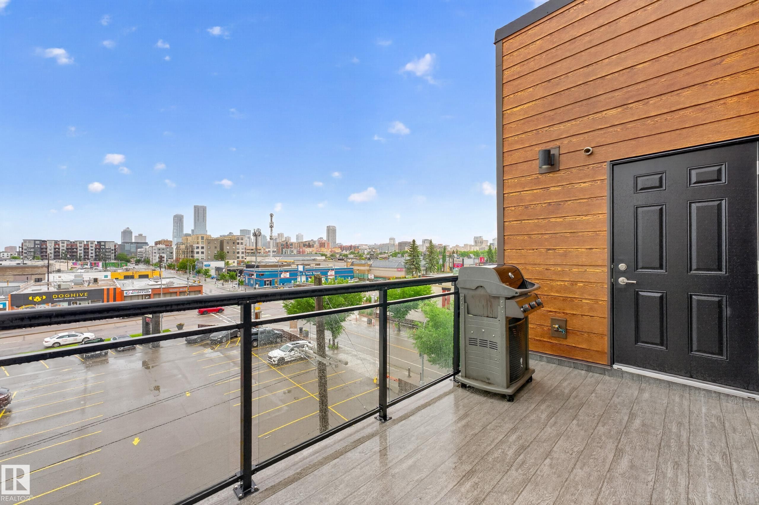 Private balcony featuring wood-finish decking and a glass railing - #410 10531 117 St Nw, Edmonton, AB