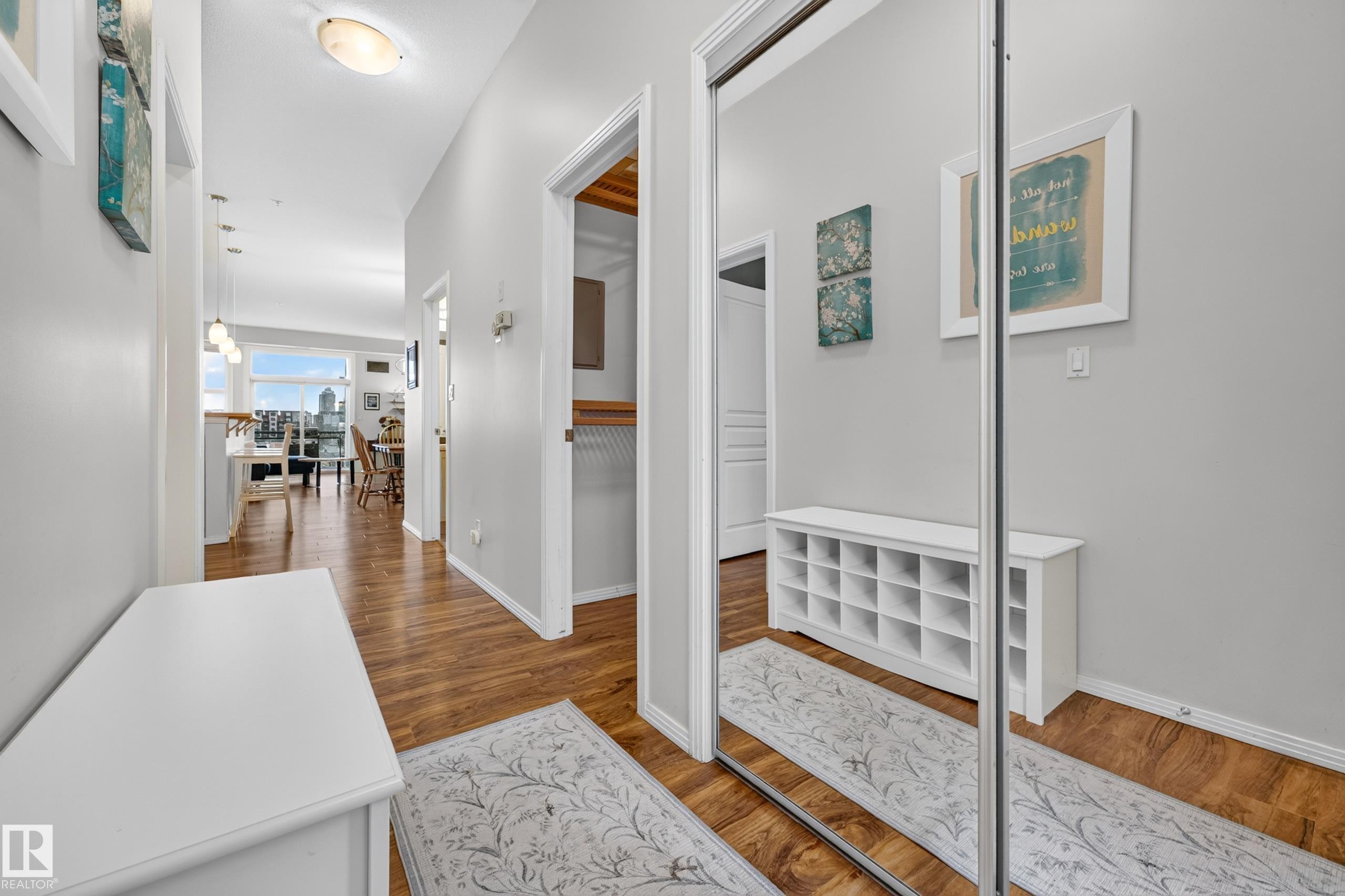 Hallway featuring wood-finish flooring, light grey painted walls, and an overhead flush-mount light fixture - #410 10531 117 St Nw, Edmonton, AB