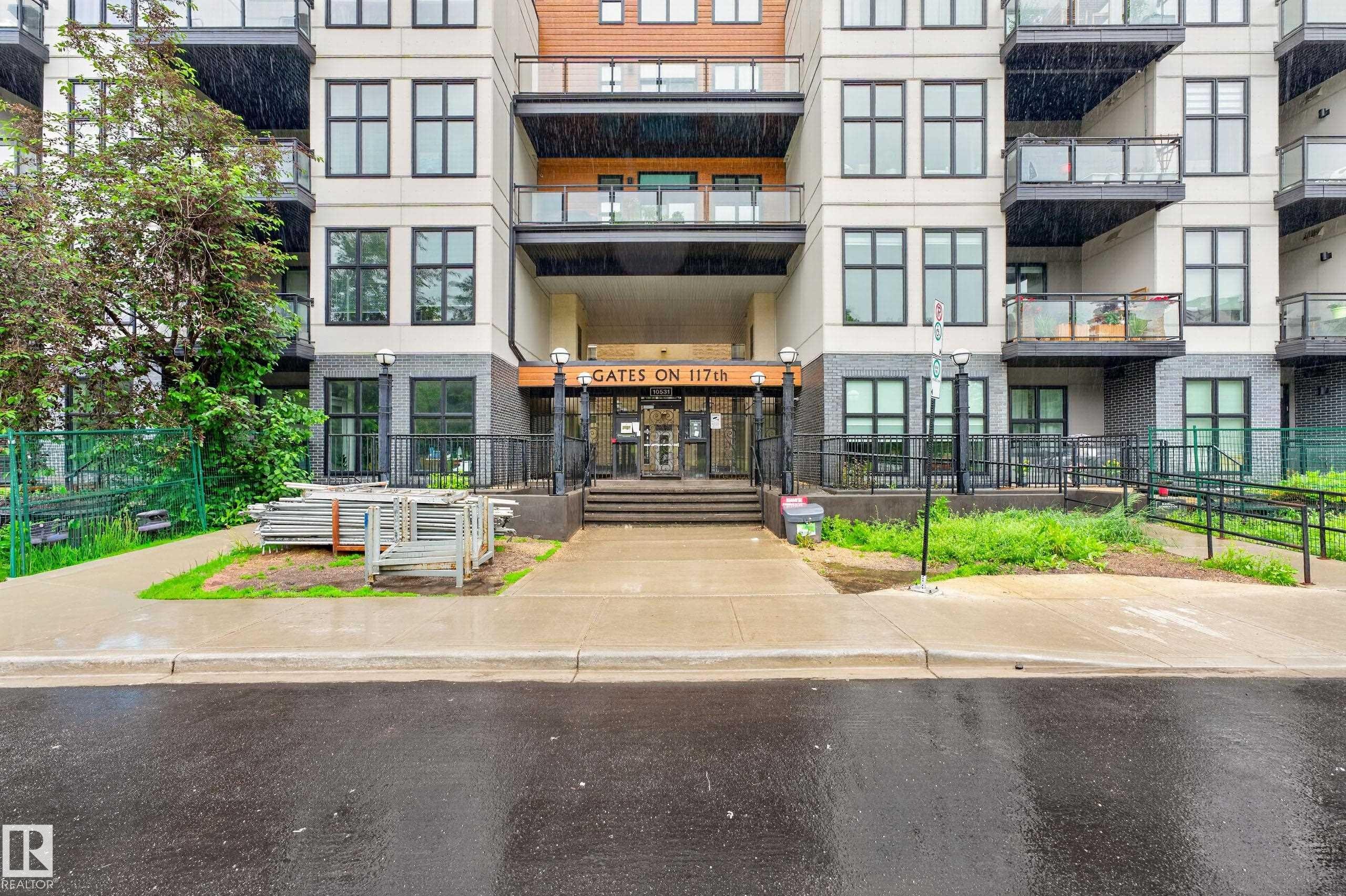 Contemporary building exterior featuring light-colored siding and dark brick accents - #410 10531 117 St Nw, Edmonton, AB