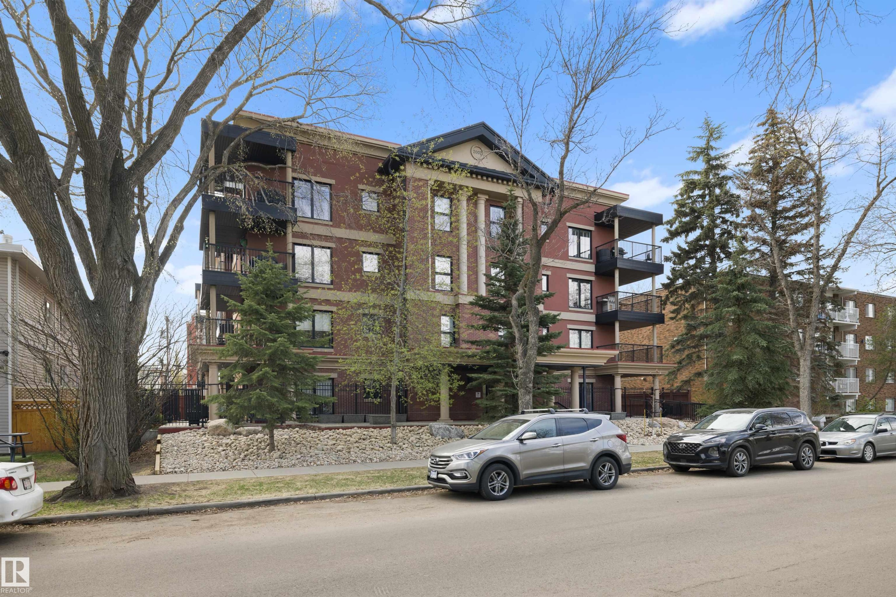 Brick exterior building featuring multiple private balconies with black railings - #206 10232 115 St Nw, Edmonton, AB