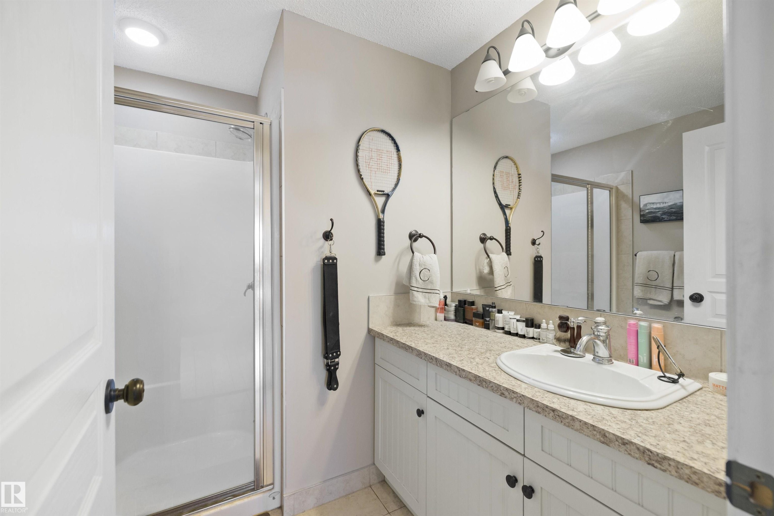 Vanity with integrated sink, speckled countertop, and white cabinetry - #206 10232 115 St Nw, Edmonton, AB