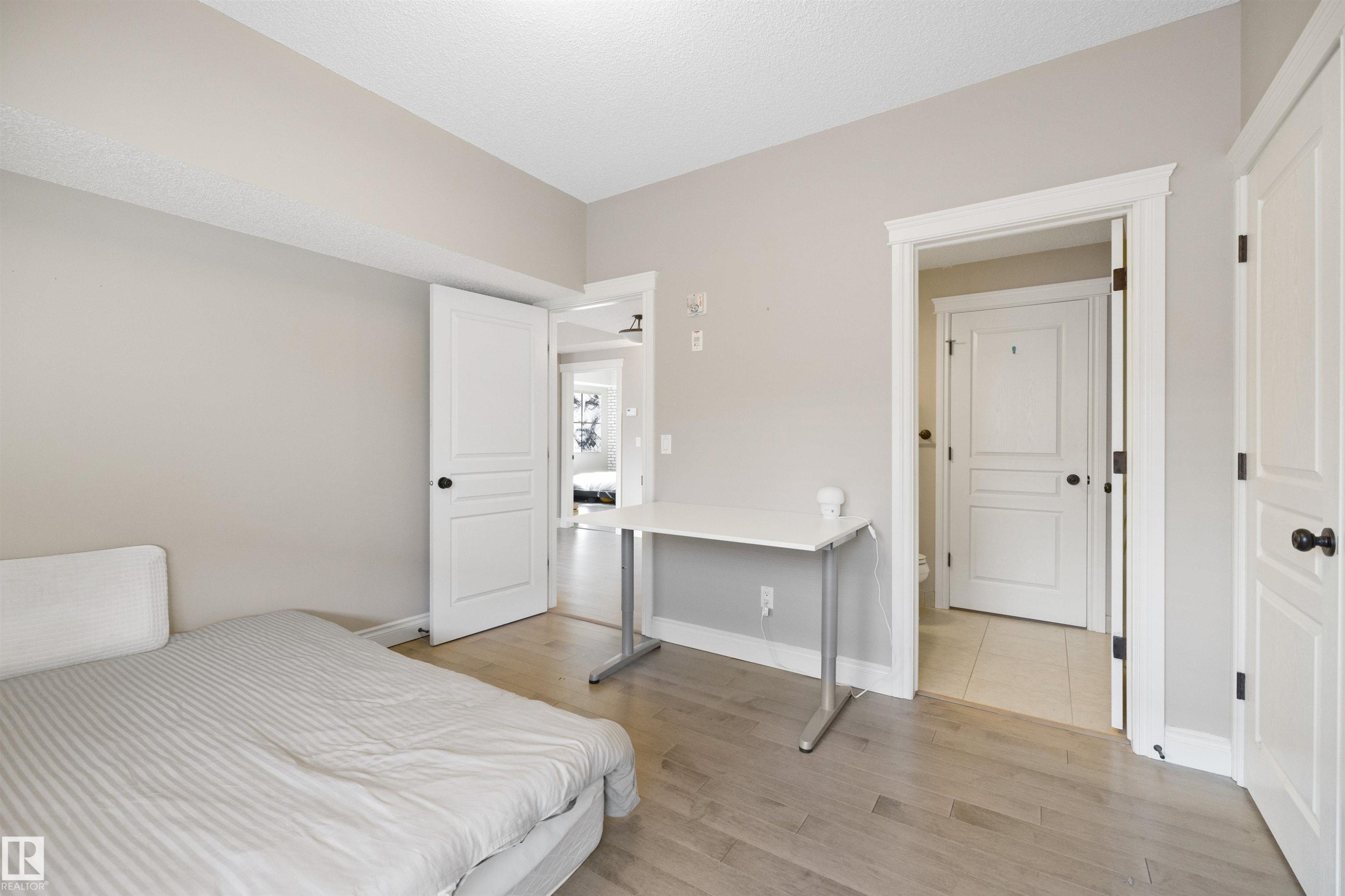 Neutral-toned room featuring light wood-finish flooring - #206 10232 115 St Nw, Edmonton, AB