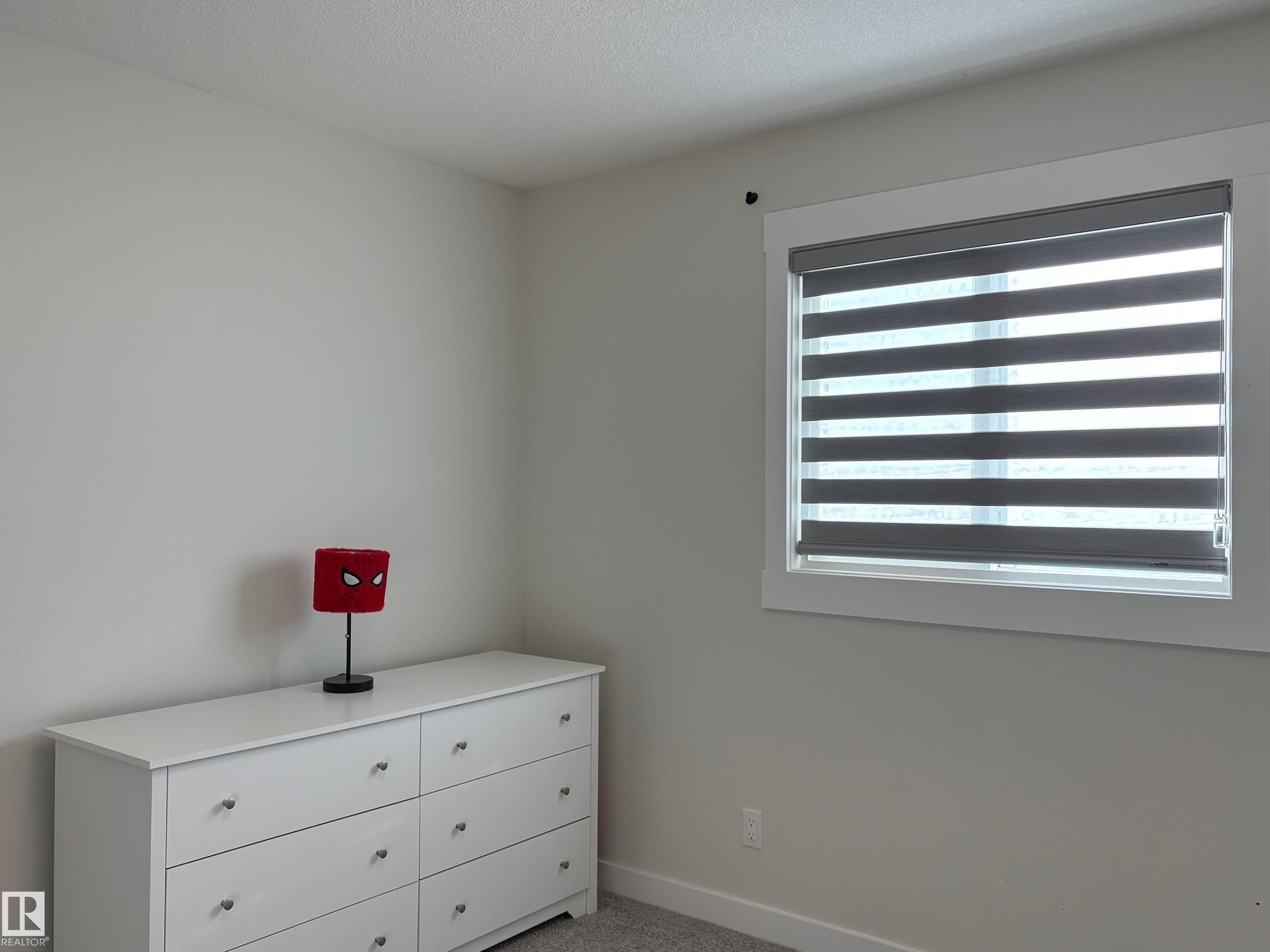 Crisp white walls with a contemporary window featuring layered privacy shades - 9952 227 Street, Edmonton, AB