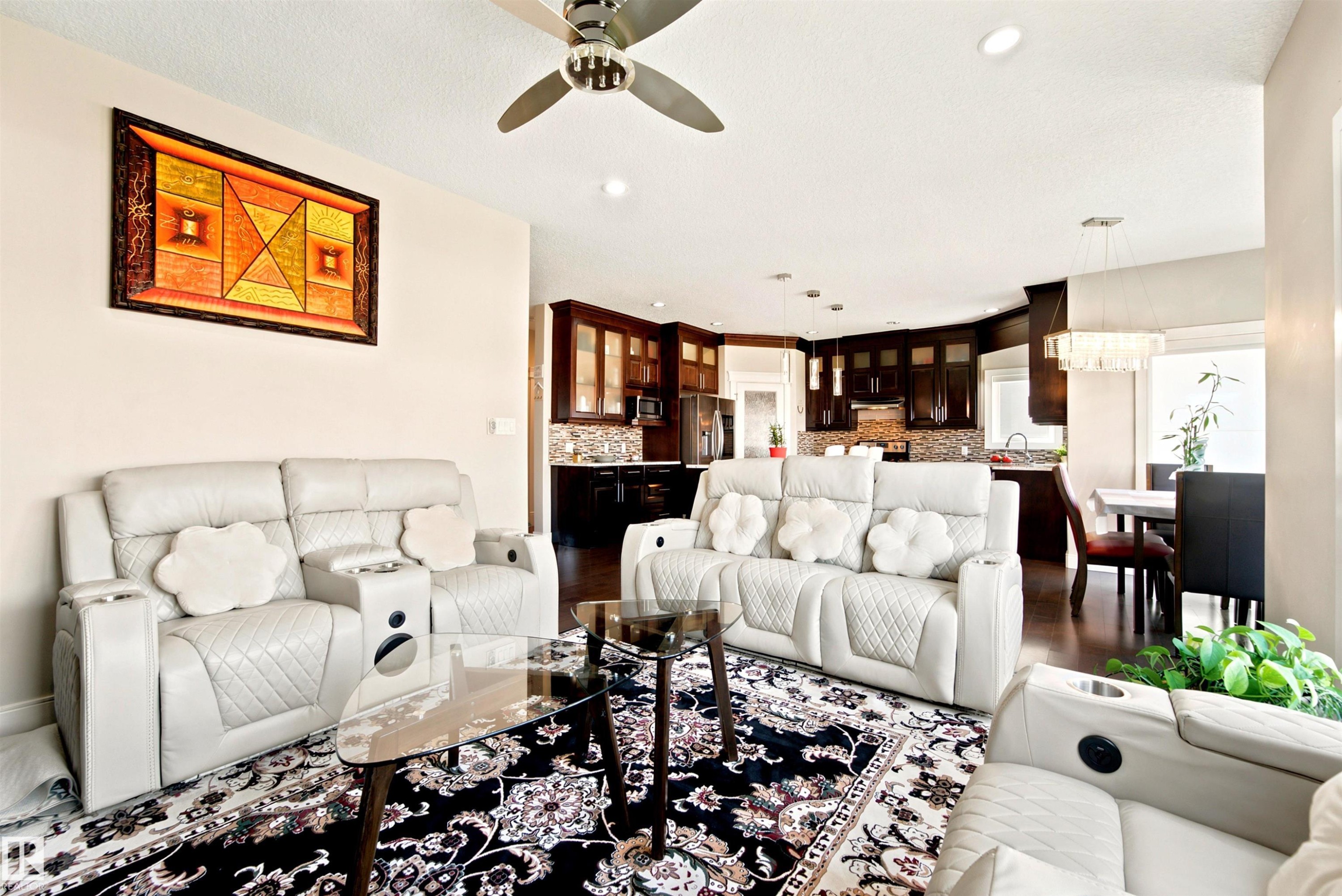 Open-concept living space featuring a ceiling fan, recessed lighting, and a dark wood-finish flooring - 5110 Rue Eaglemont, Beaumont, AB