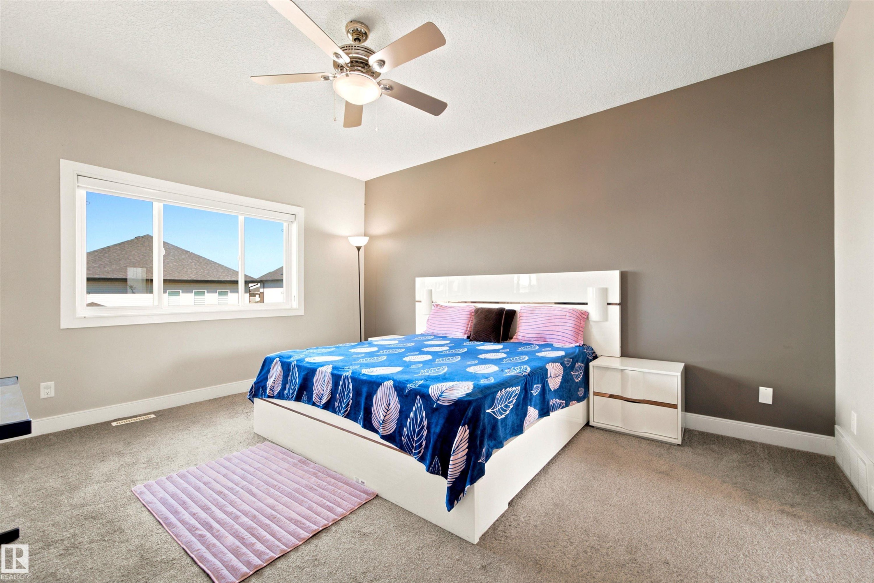 Spacious interior featuring a neutral color palette, recessed window, and ceiling fan with integrated lighting - 5110 Rue Eaglemont, Beaumont, AB