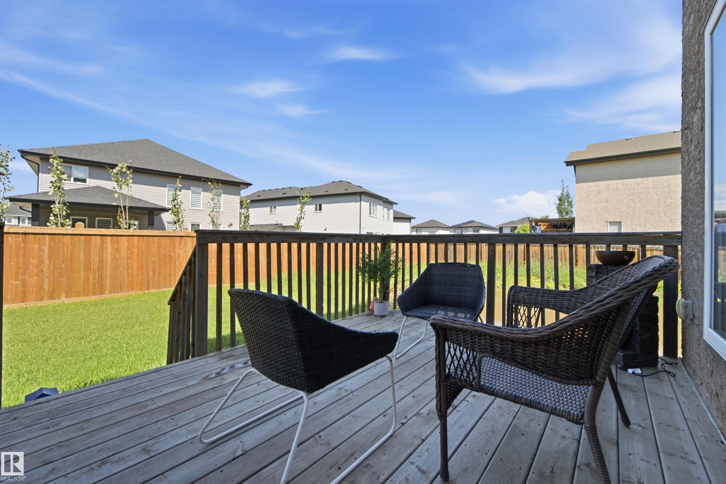 Spacious outdoor deck featuring weathered wood planks and a wooden railing - 5110 Rue Eaglemont, Beaumont, AB