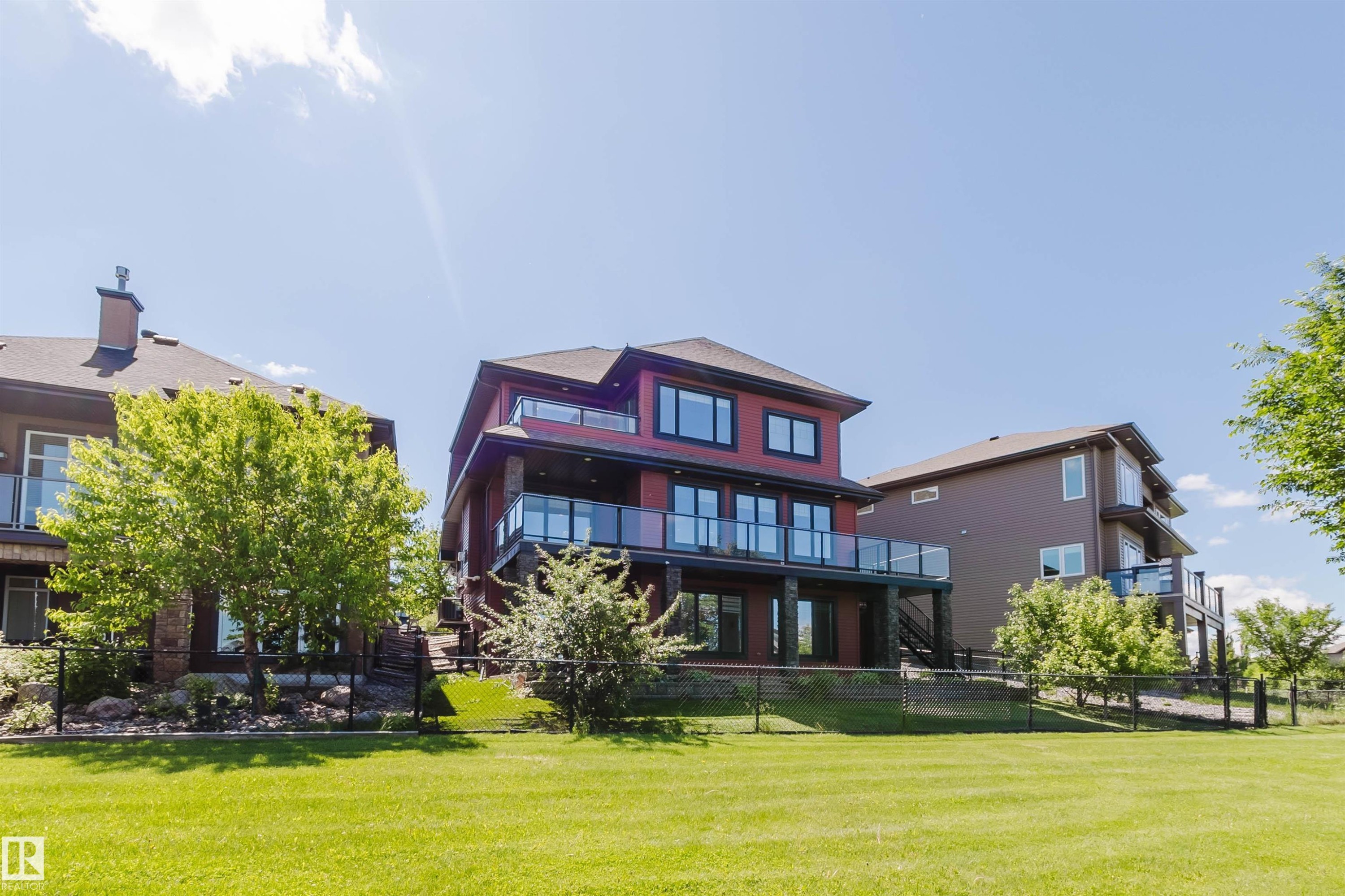 Multi-story residential property featuring a red exterior with multiple balconies - 3438 West Landing Landing, Edmonton, AB