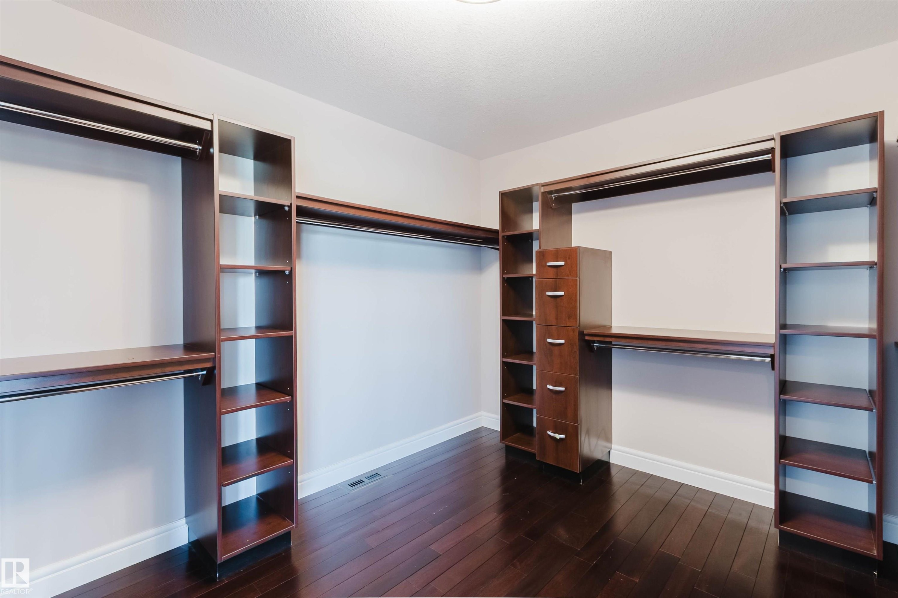 Custom closet system featuring dark wood-finish components - 3438 West Landing Landing, Edmonton, AB
