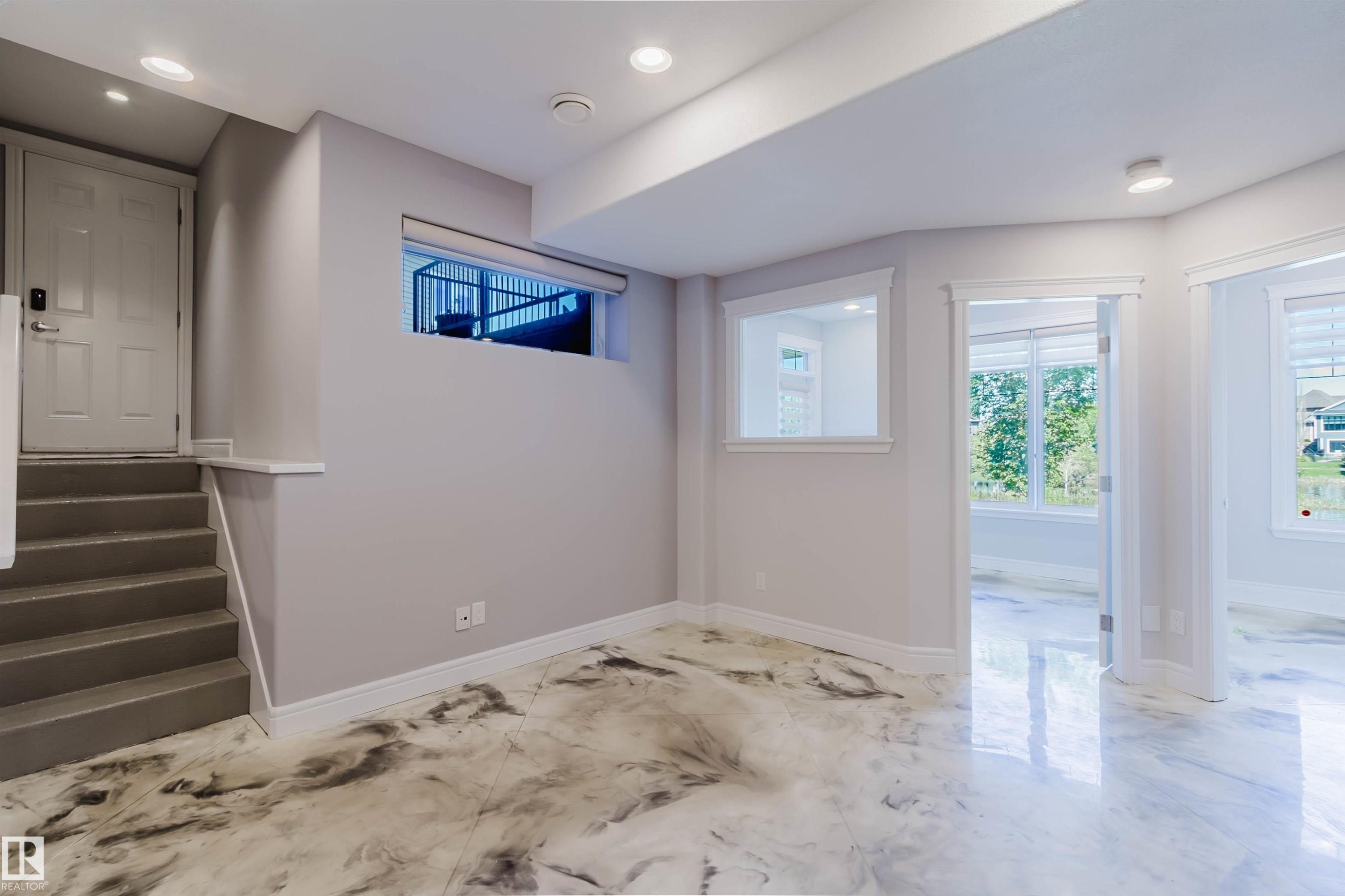 Spacious open area featuring distinctive high-gloss flooring, recessed lighting, and multiple windows providing natural illumination - 3438 West Landing Landing, Edmonton, AB
