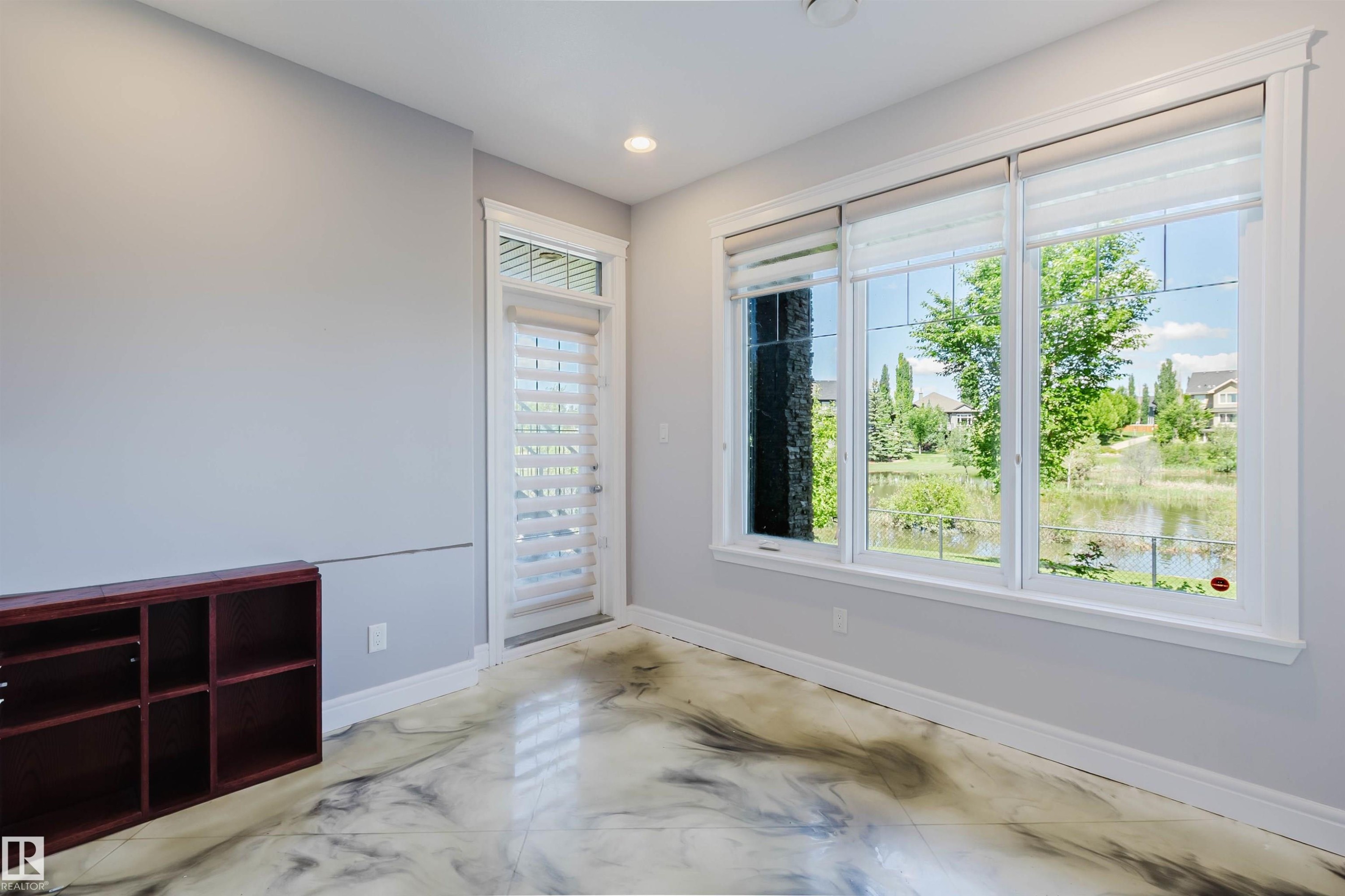 Light gray walls and white trim complement the unique marbled epoxy flooring - 3438 West Landing Landing, Edmonton, AB