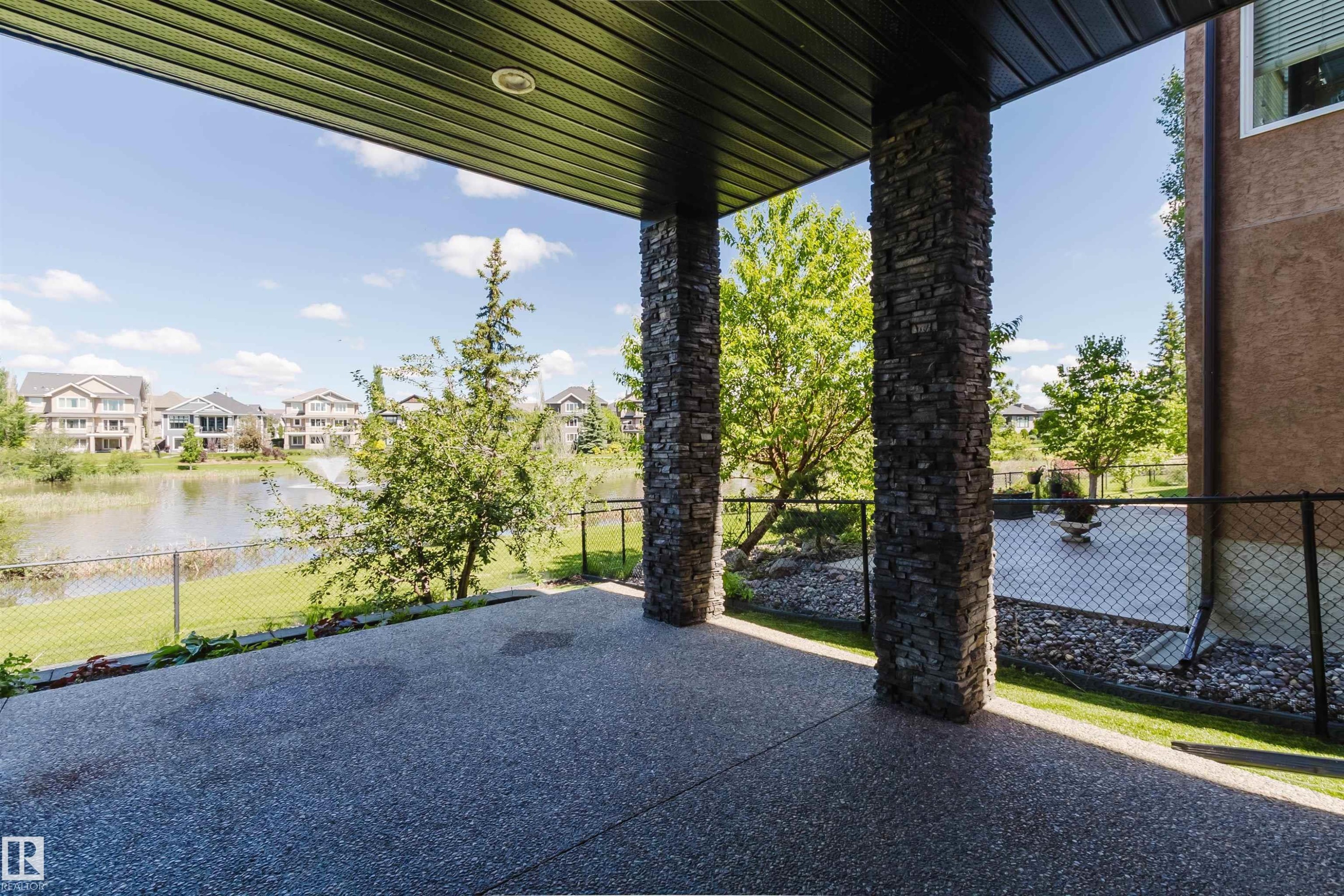 Covered patio featuring an exposed aggregate surface and stone-clad pillars - 3438 West Landing Landing, Edmonton, AB