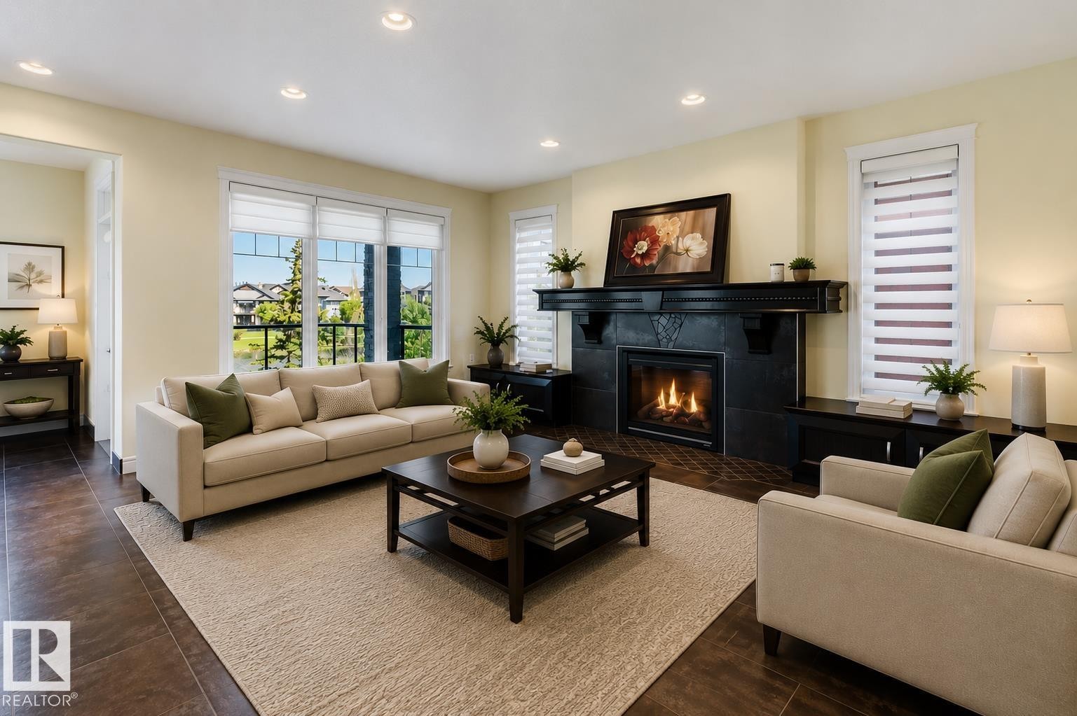 Spacious living area featuring a prominent fireplace with a dark mantel, recessed lighting, and wood-finish flooring - 3438 West Landing Landing, Edmonton, AB