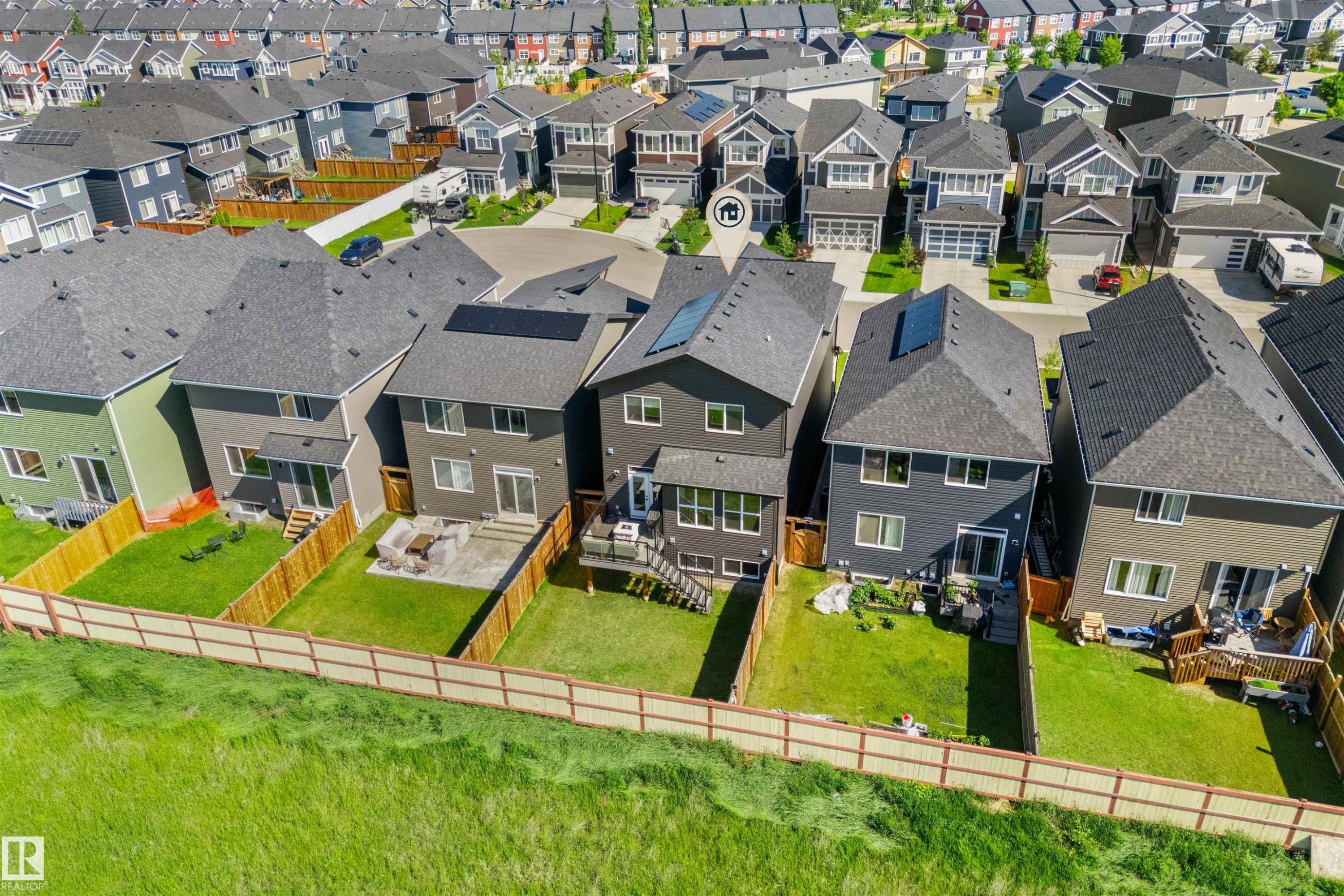 Modern residential architecture featuring a dark gray exterior, prominent solar panels, and a gabled roofline - 19 Sturtz Place, Leduc, AB