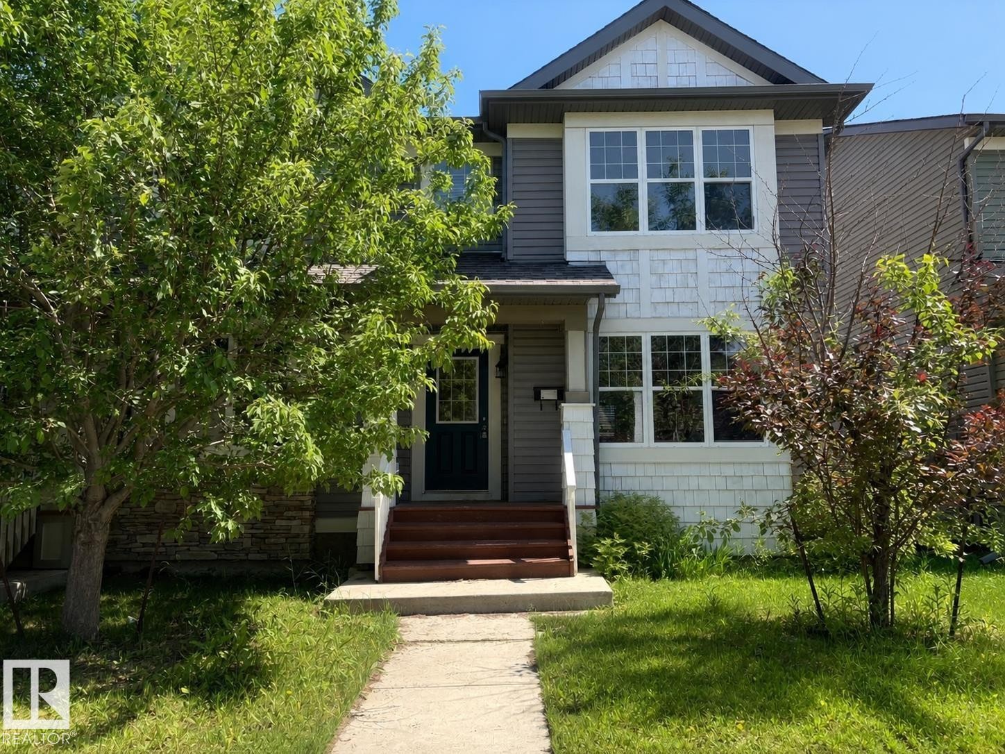 Contemporary exterior featuring gray horizontal siding and white shingle accents - 2143 32 Street, Edmonton, AB