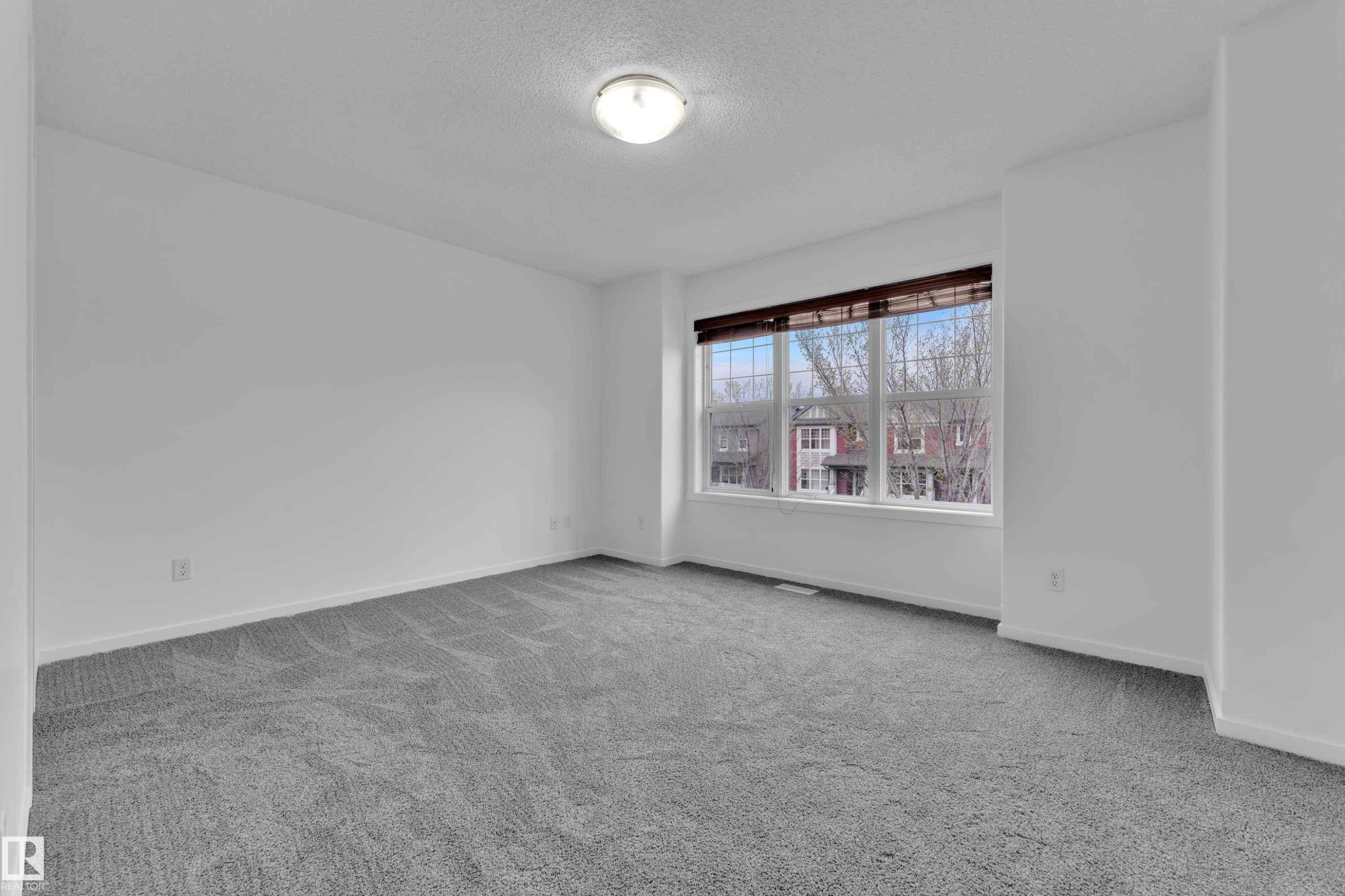 Spacious room featuring neutral carpeting and white wall finishes - 2143 32 Street, Edmonton, AB