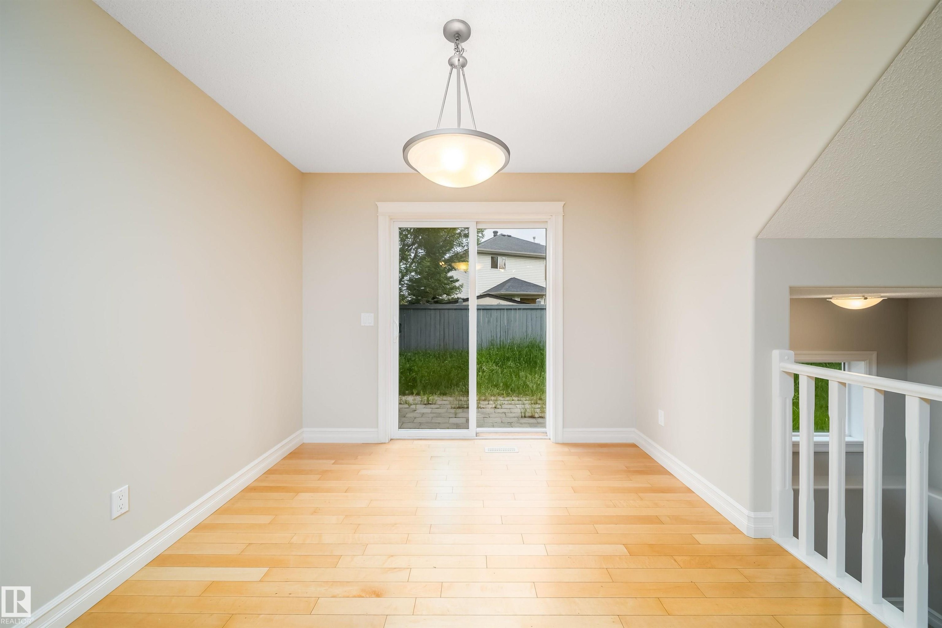 Bright interior space featuring light wood-finish flooring, neutral wall tones, and white trim - 11312 13 Ave Sw, Edmonton, AB