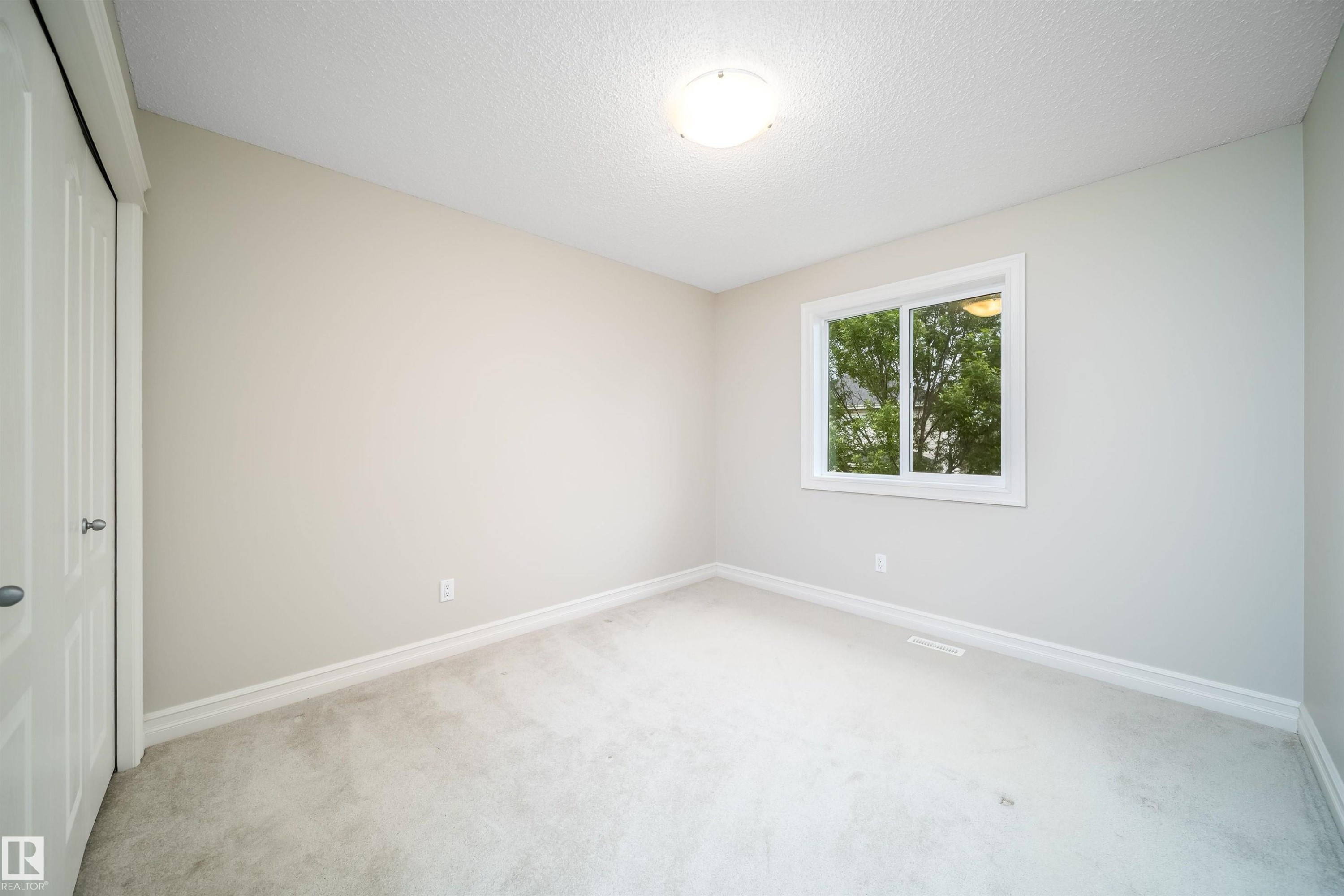 Bright room featuring a double-pane window, neutral-toned walls, and light-colored carpeting - 11312 13 Ave Sw, Edmonton, AB
