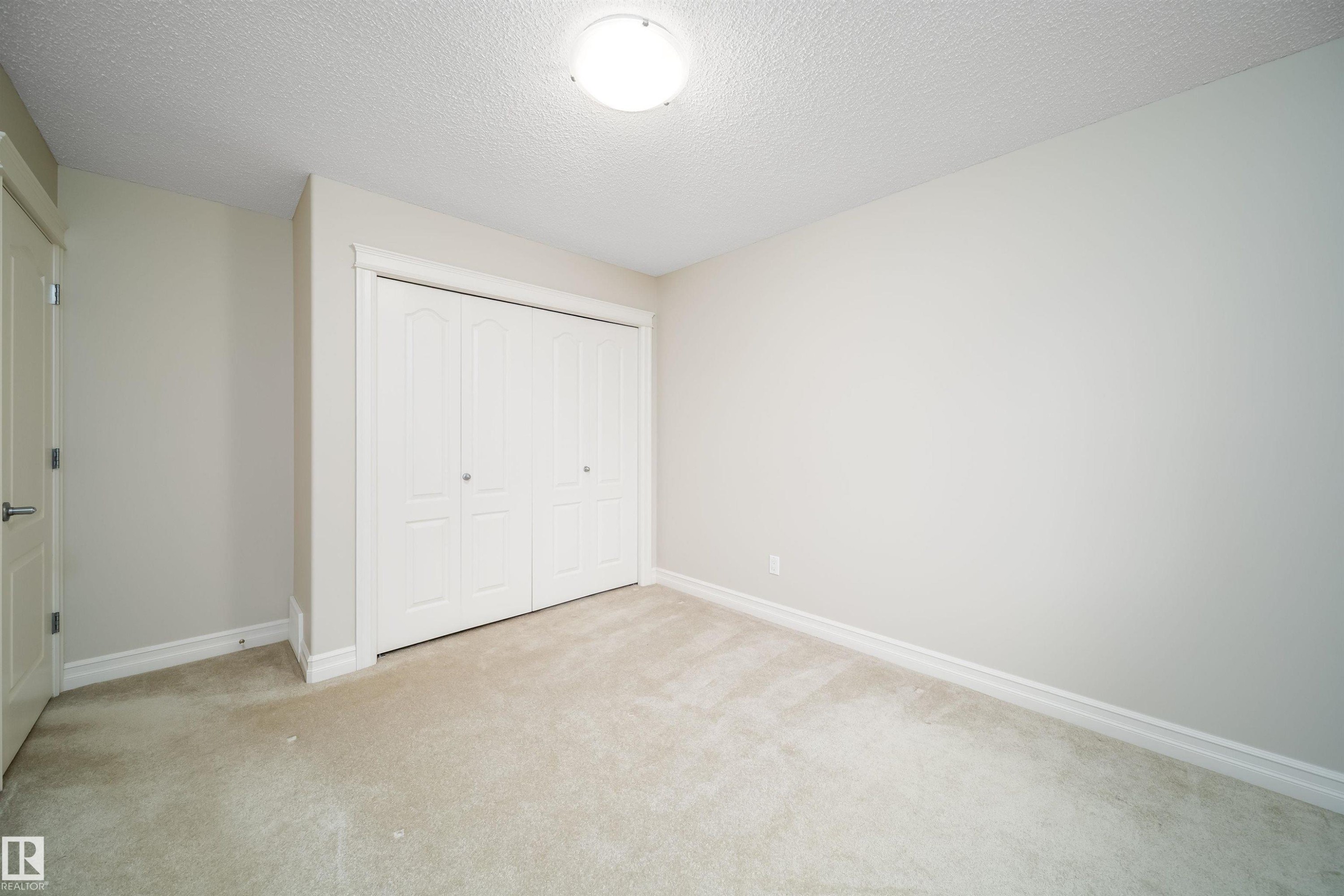 Neutral-toned carpeting paired with light wall paint - 11312 13 Ave Sw, Edmonton, AB