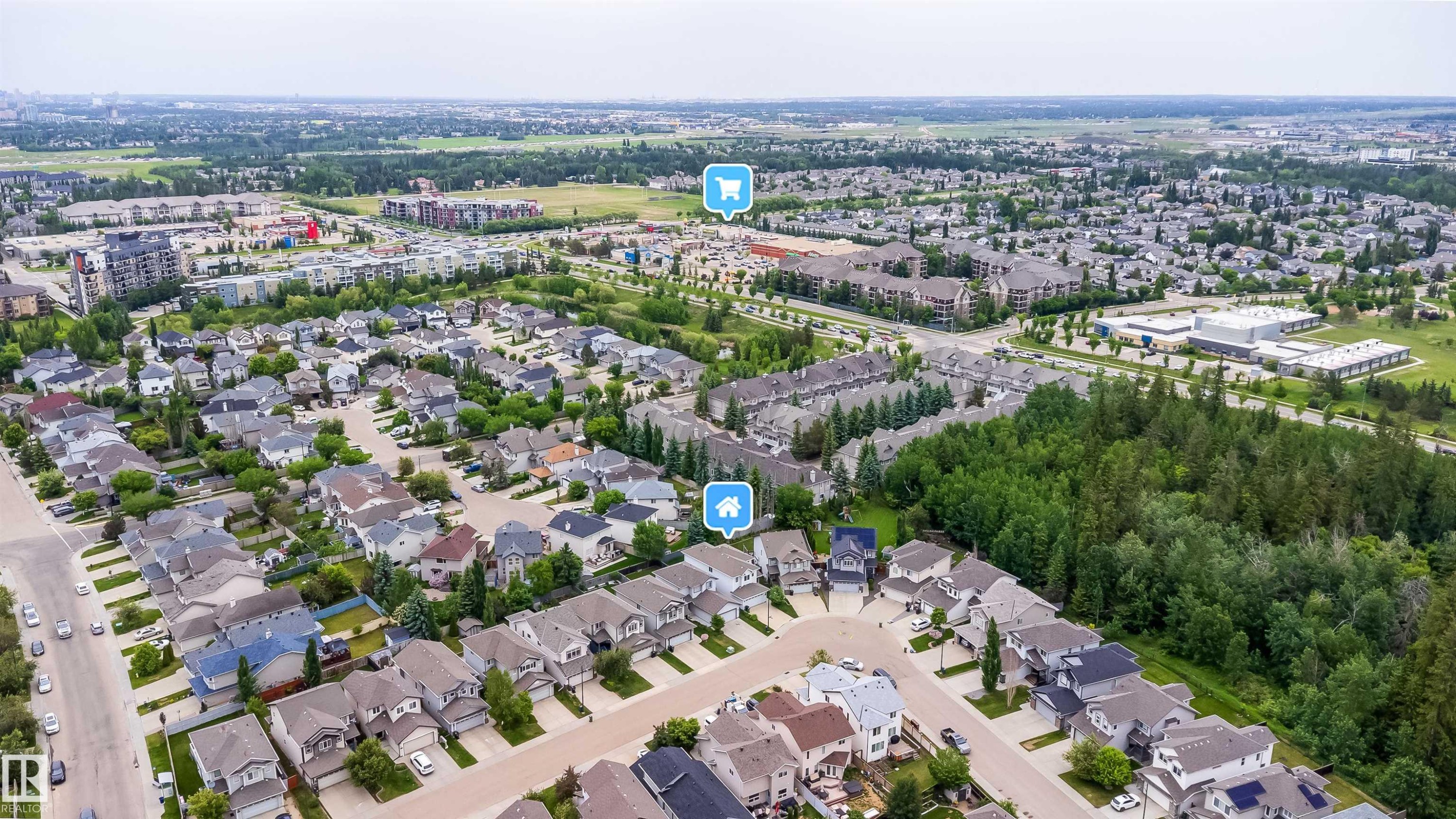 Aerial perspective showcasing a residential area with varied housing styles, surrounded by green spaces and mature trees - 11312 13 Ave Sw, Edmonton, AB
