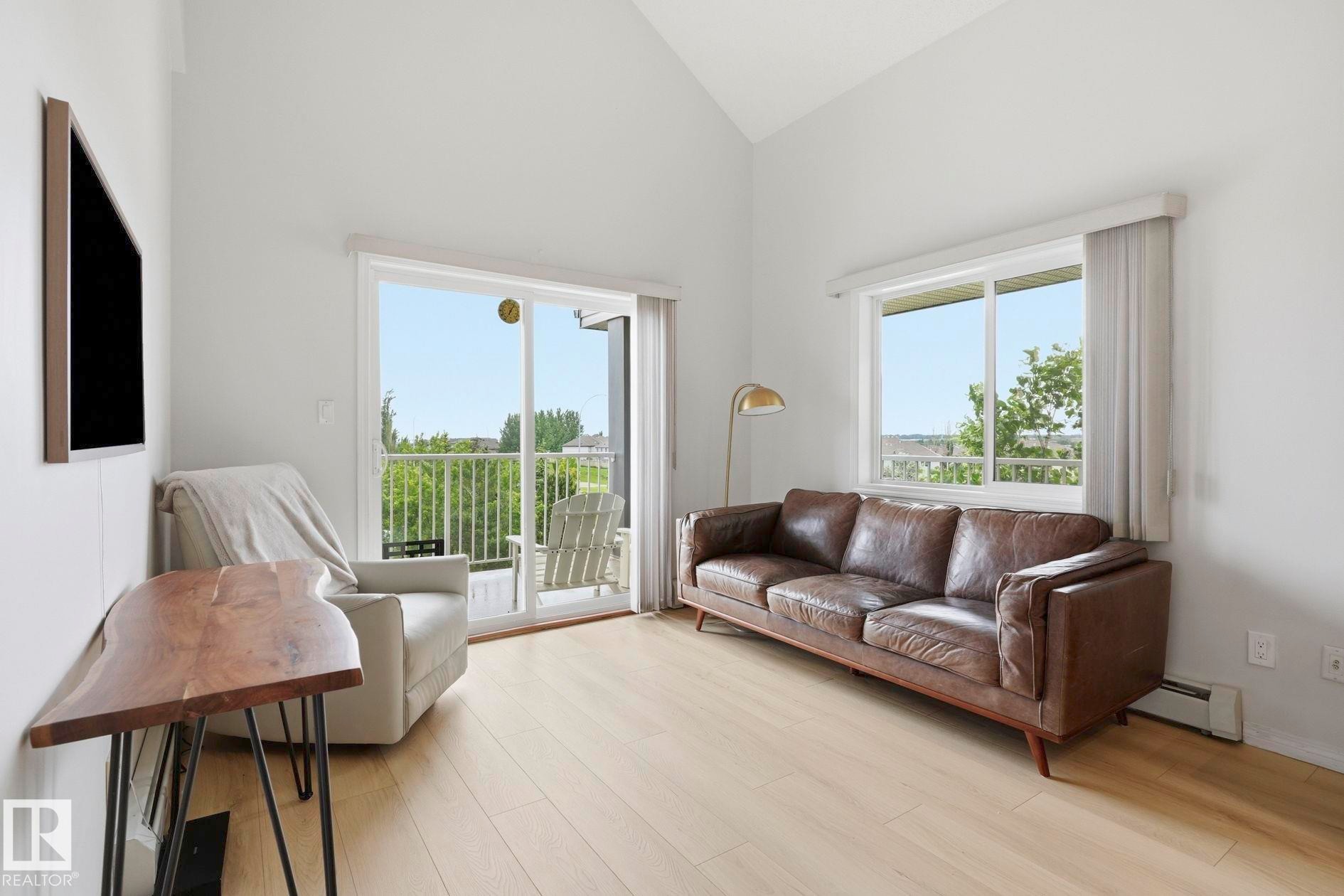 Vaulted ceilings complement light wood-finish flooring - #426 3425 19 St Nw, Edmonton, AB