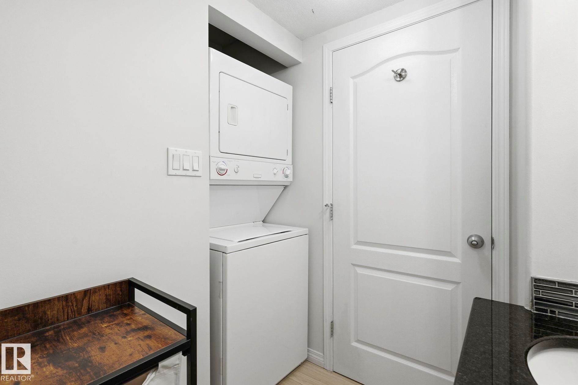Dedicated laundry area featuring a stacked washer and dryer unit - #426 3425 19 St Nw, Edmonton, AB