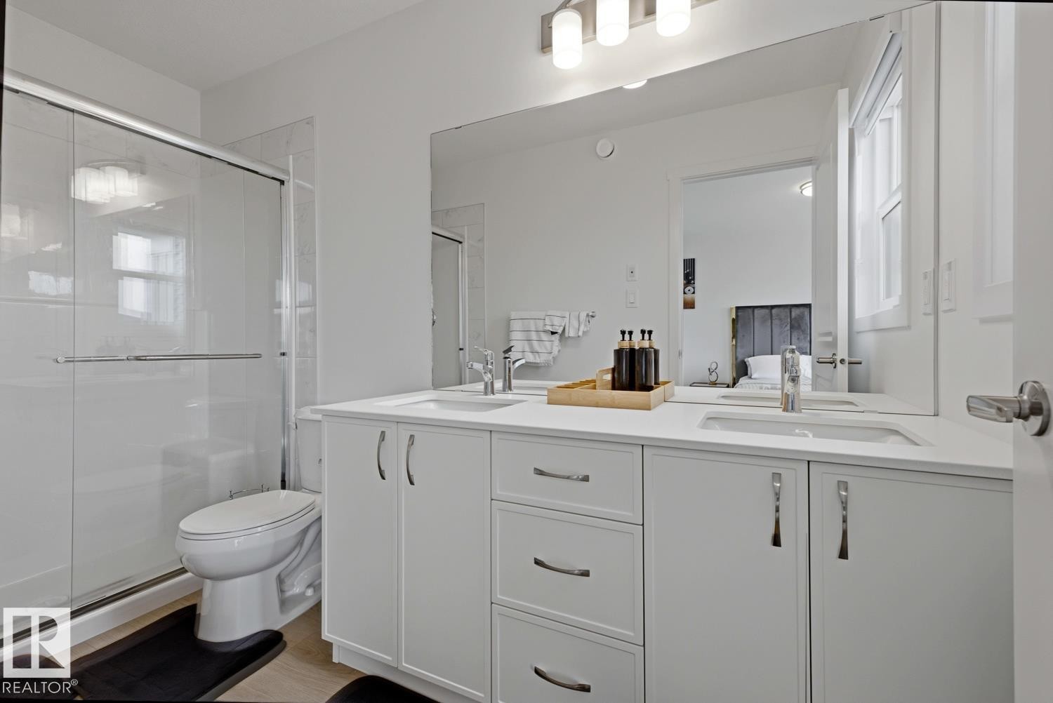 Contemporary bathroom featuring a double vanity with ample storage, a spacious wall mirror, a glass-enclosed shower, and sleek fixtures - 22924 82 Ave Nw, Edmonton, AB - Indoor Photo Showing Bathroom
