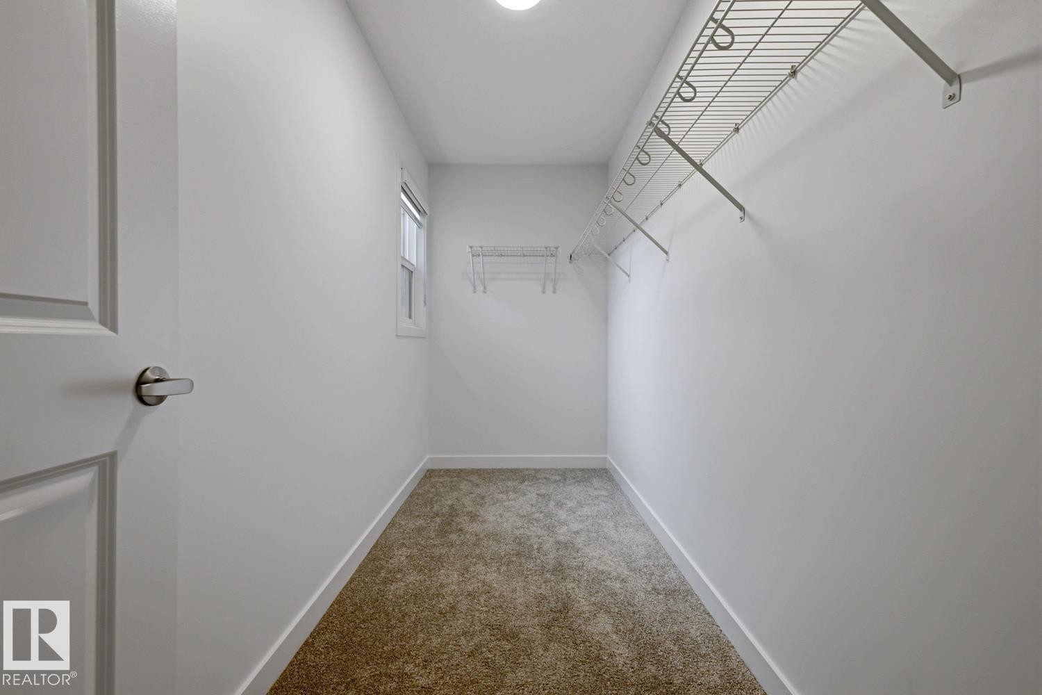 Spacious walk-in closet featuring light-colored carpeting, white walls, and wire shelving - 22924 82 Ave Nw, Edmonton, AB - Indoor