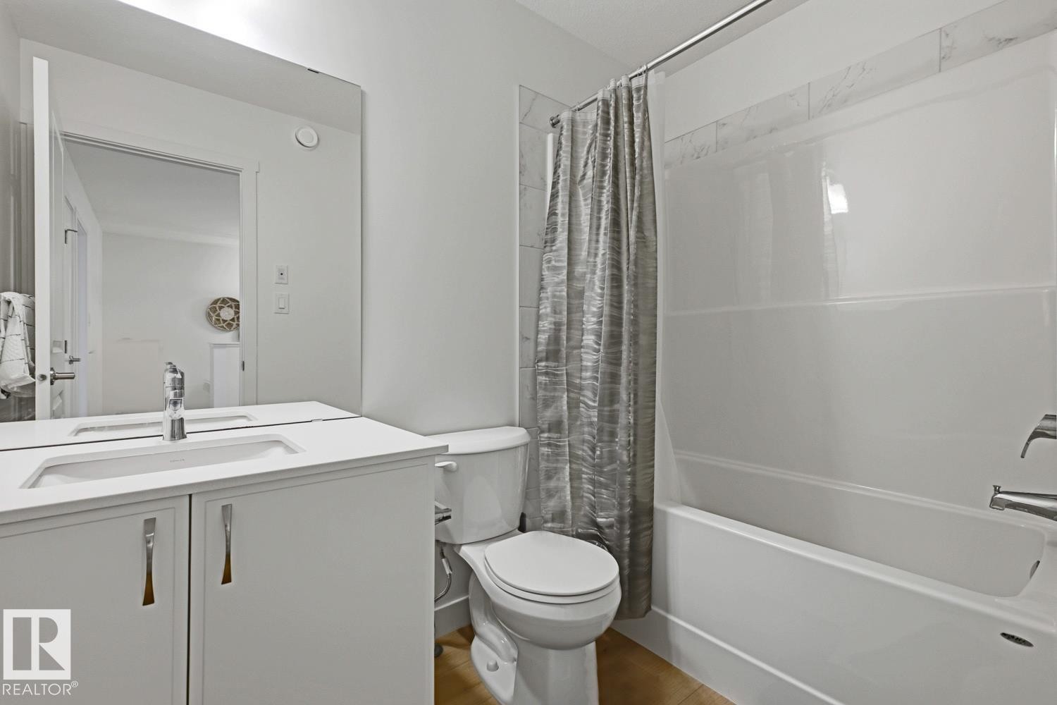 Bathroom featuring a white vanity with an integrated sink, polished chrome faucet, and a large frameless mirror - 22924 82 Ave Nw, Edmonton, AB - Indoor Photo Showing Bathroom