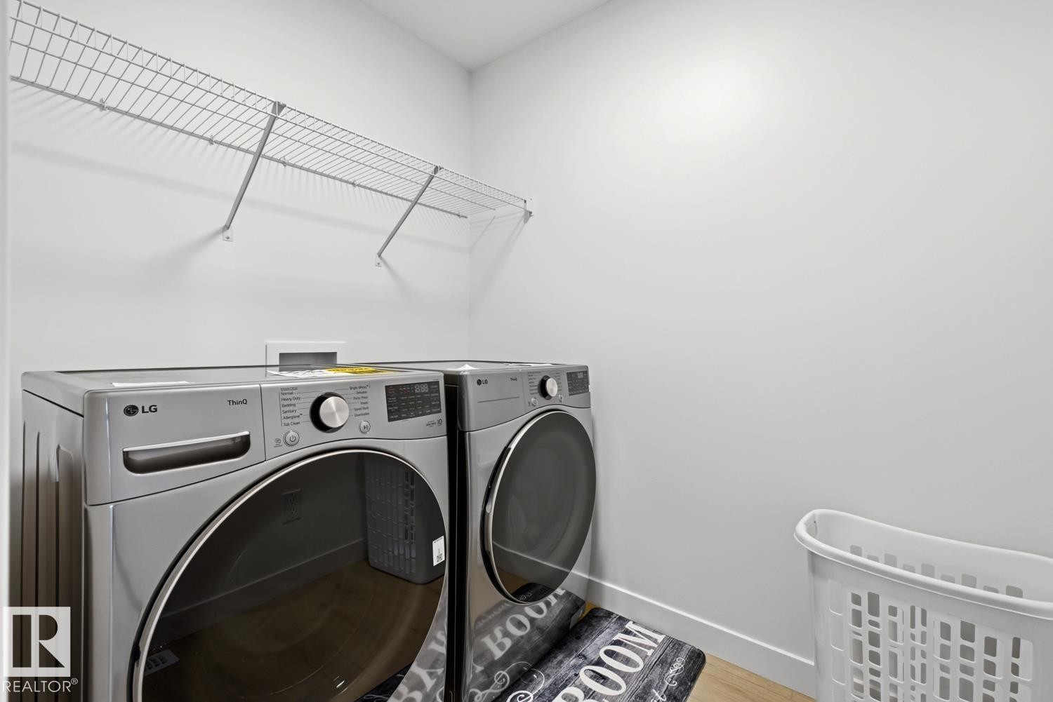 Laundry area with light-colored walls and wood-finish flooring - 22924 82 Ave Nw, Edmonton, AB - Indoor Photo Showing Laundry Room