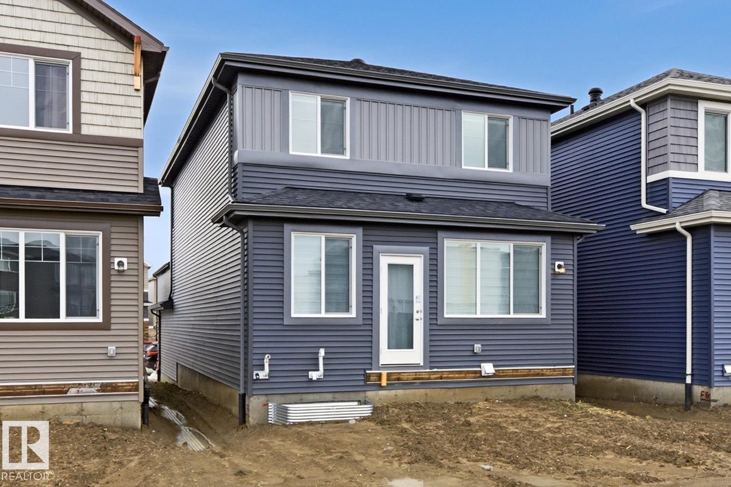 Two-story residence featuring a blue and gray horizontal siding exterior, white-framed windows, and a black shingle roof - 22924 82 Ave Nw, Edmonton, AB - Outdoor