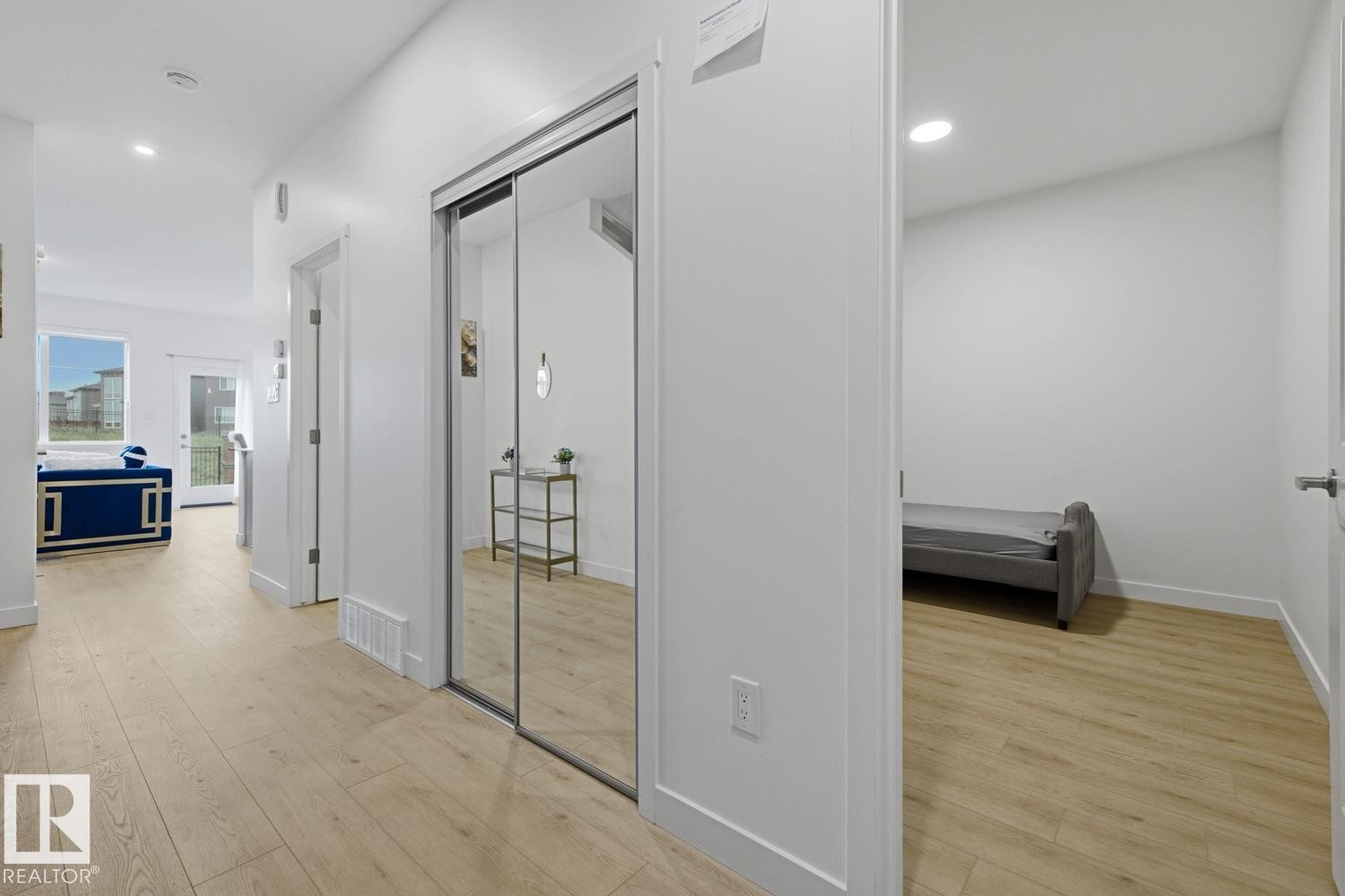 Light wood-finish flooring extends through this space, featuring white walls and recessed lighting - 22924 82 Ave Nw, Edmonton, AB - Indoor Photo Showing Other Room