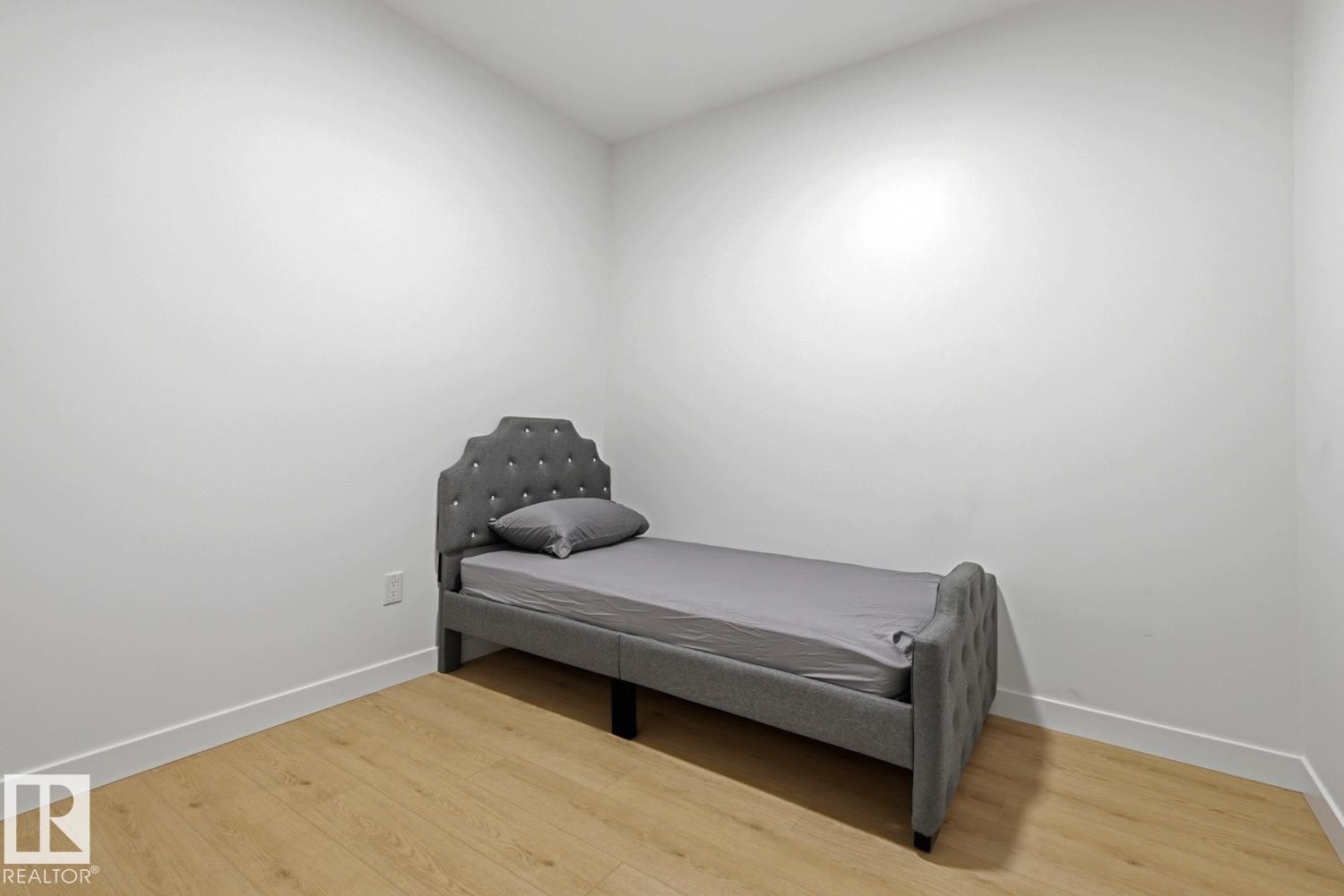 Room featuring neutral wall tones, wood-finish flooring, and white baseboards - 22924 82 Ave Nw, Edmonton, AB - Indoor Photo Showing Bedroom