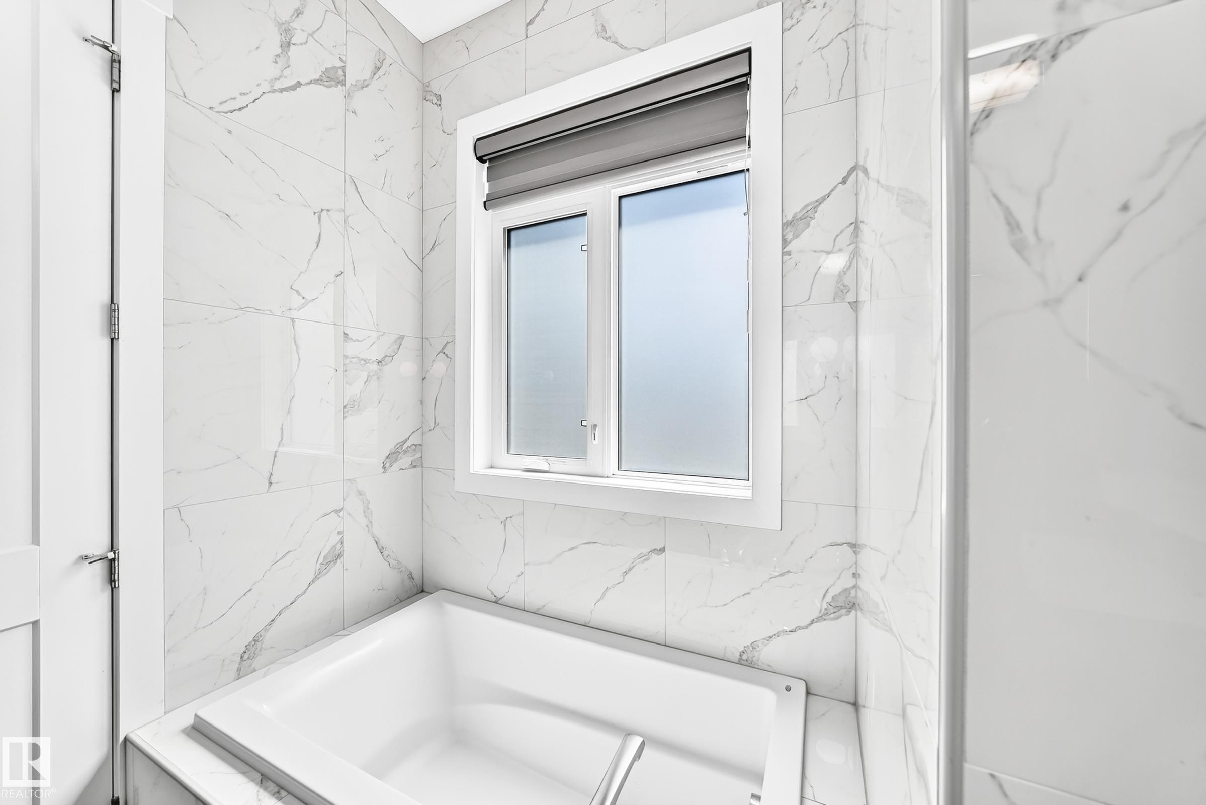 White porcelain tub with a tiled surround - 1781 Melrose Crescent, Edmonton, AB