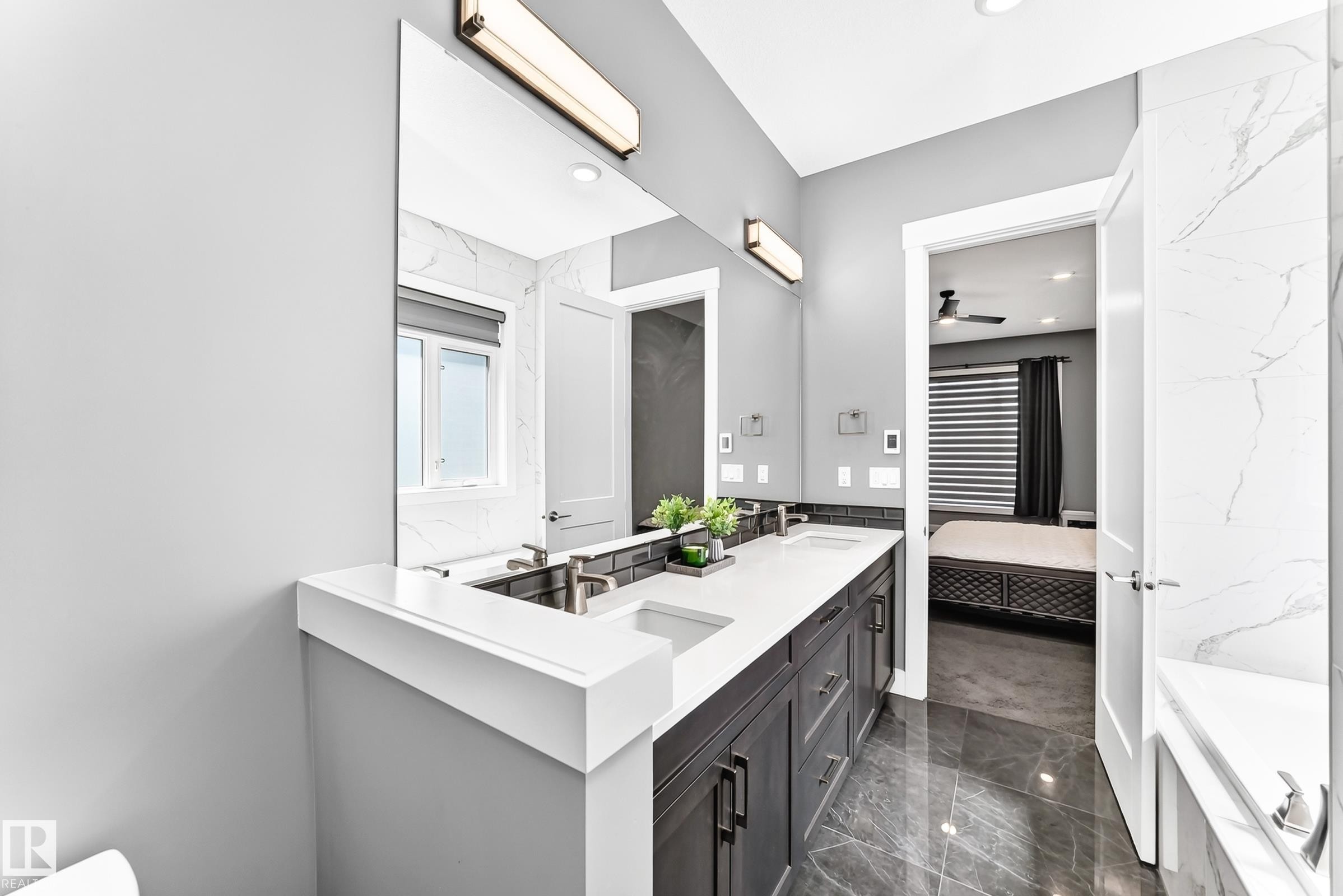 Bathroom featuring a dual vanity with dark cabinetry, white countertops, and undermount sinks - 1781 Melrose Crescent, Edmonton, AB