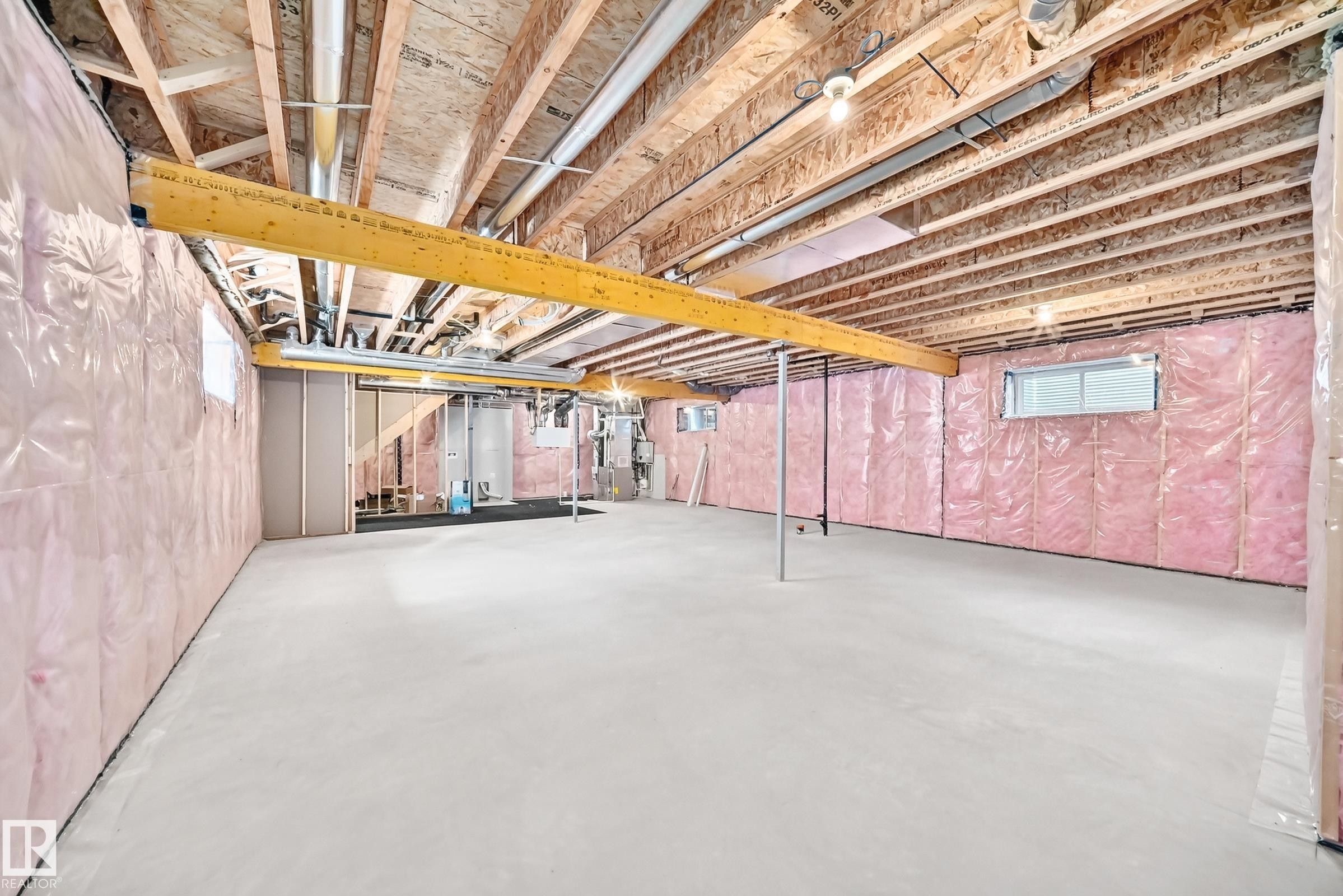 Unfinished basement with exposed ceiling joists and subfloor, insulated walls, concrete flooring, and multiple egress windows - 1781 Melrose Crescent, Edmonton, AB