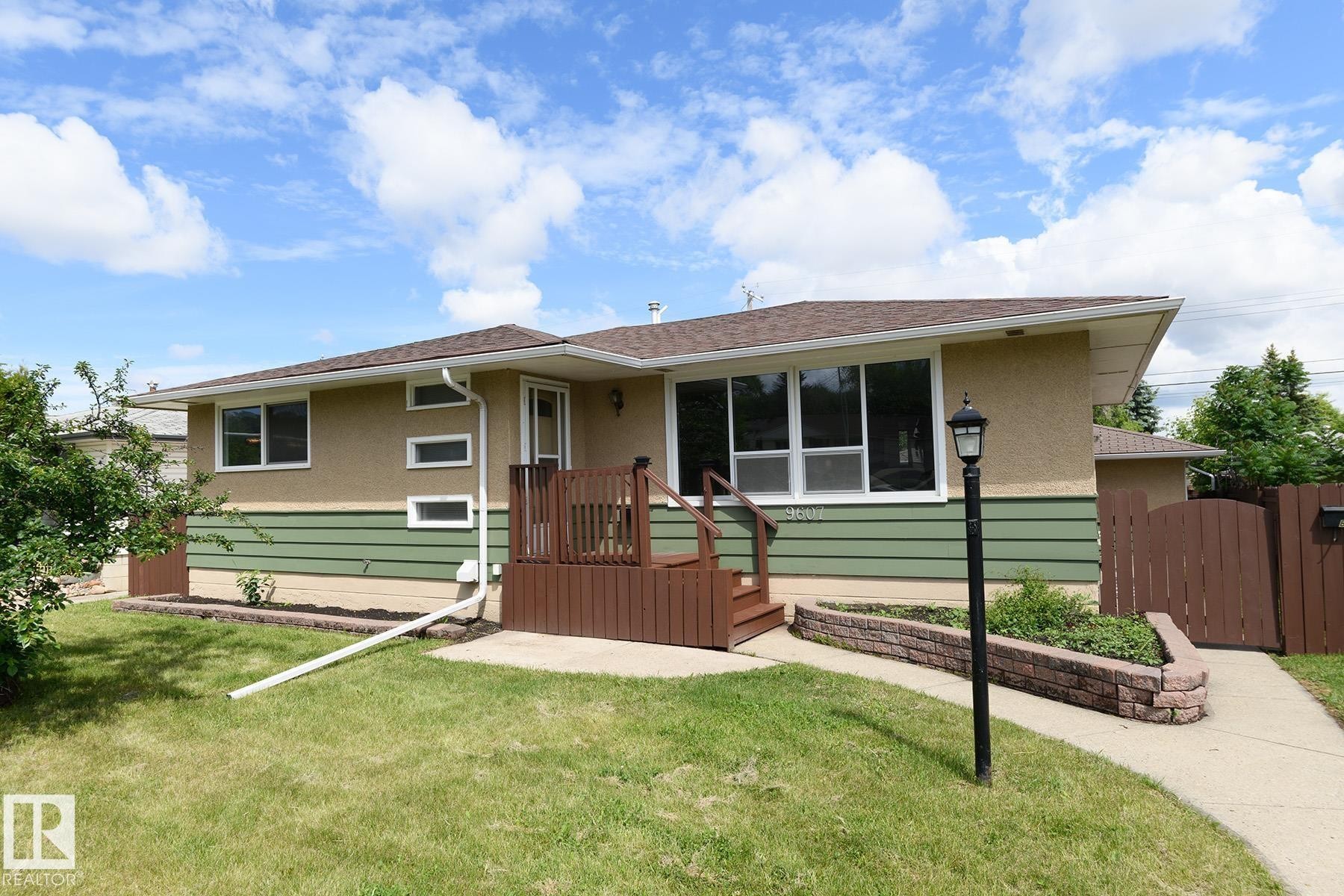 Ranch-style exterior featuring a composite shingle roof and a combination of stucco and horizontal siding - 9607 75 Street, Edmonton, AB