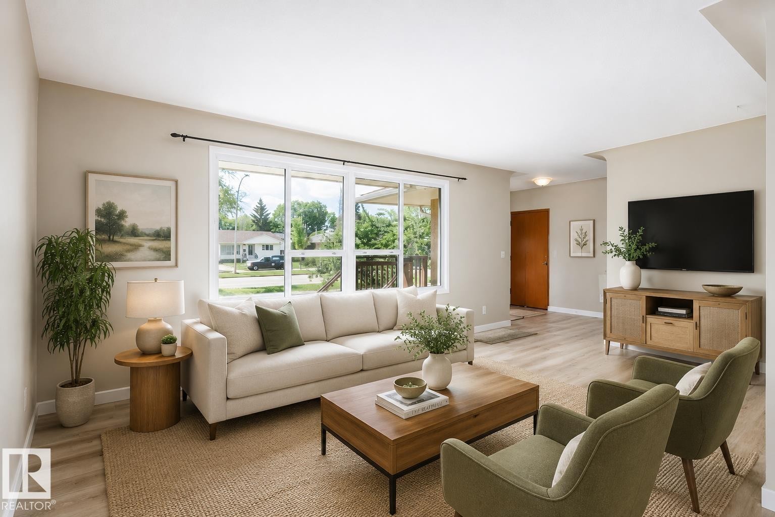 Spacious living area featuring light wood-finish flooring, a large window providing ample natural light, neutral wall colors, recessed ceiling lighting, and a solid wood entry door - 9607 75 Street, Edmonton, AB