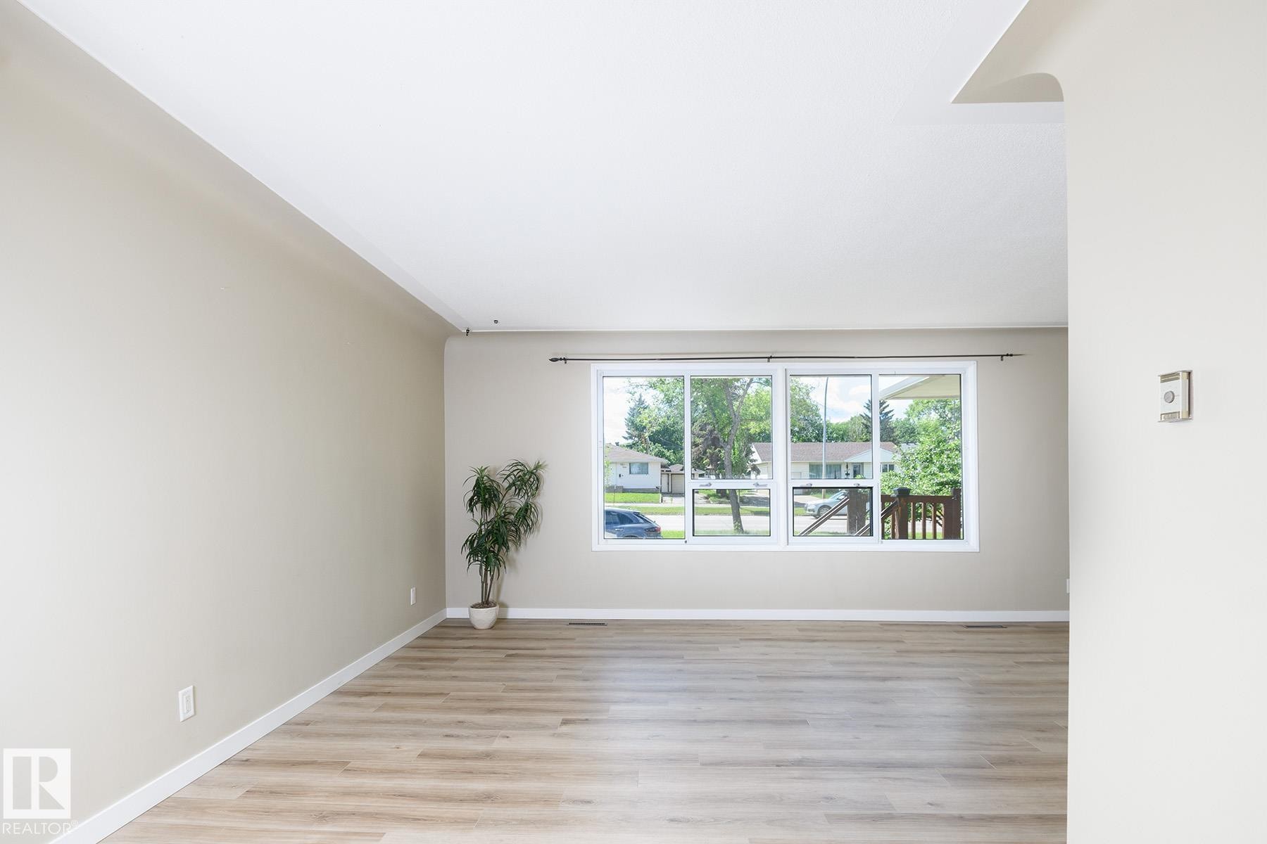 Bright interior featuring neutral painted walls, white trim, and wood-finish flooring - 9607 75 Street, Edmonton, AB