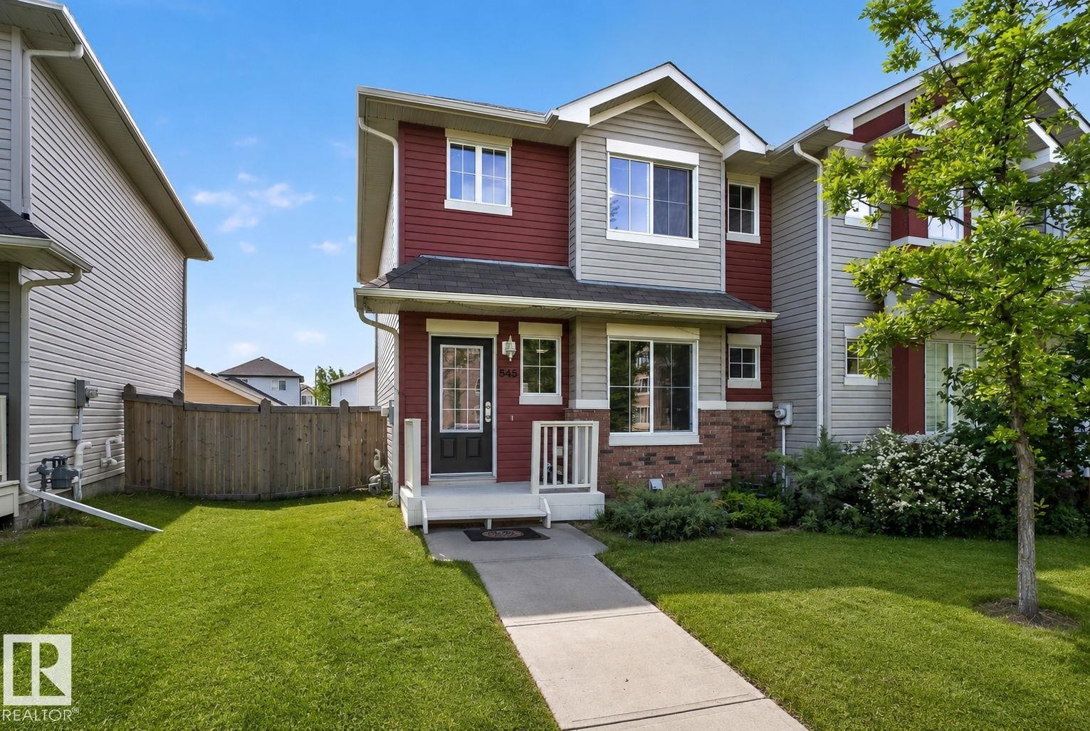 Two-story residential exterior featuring red and gray siding with brick accents - 545 Watt Boulevard Sw, Edmonton, AB - Outdoor With Facade