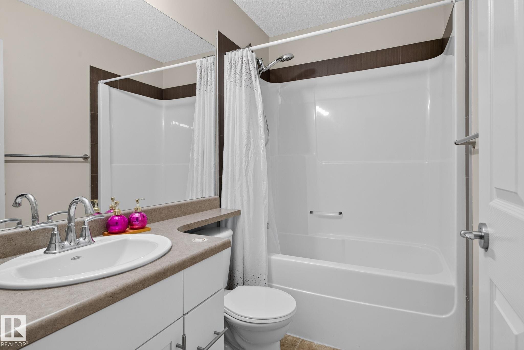 Bathroom featuring a white vanity with an oval sink, chrome faucet, and a light-toned countertop - 545 Watt Boulevard Sw, Edmonton, AB - Indoor Photo Showing Bathroom
