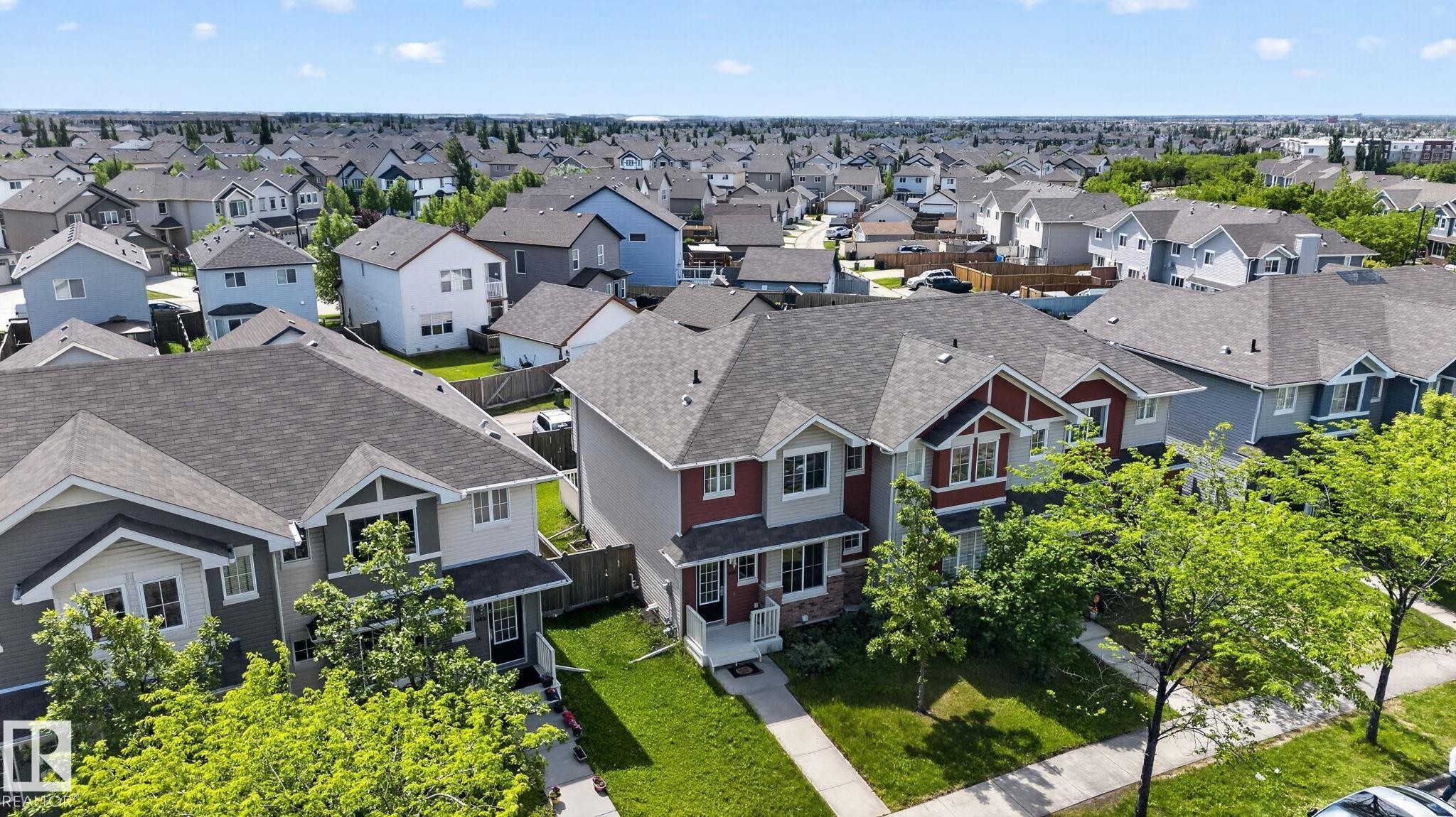 Suburban residential area featuring a collection of detached and semi-detached homes with pitched roofs, front yards, and mature trees - 545 Watt Boulevard Sw, Edmonton, AB - Outdoor With Facade